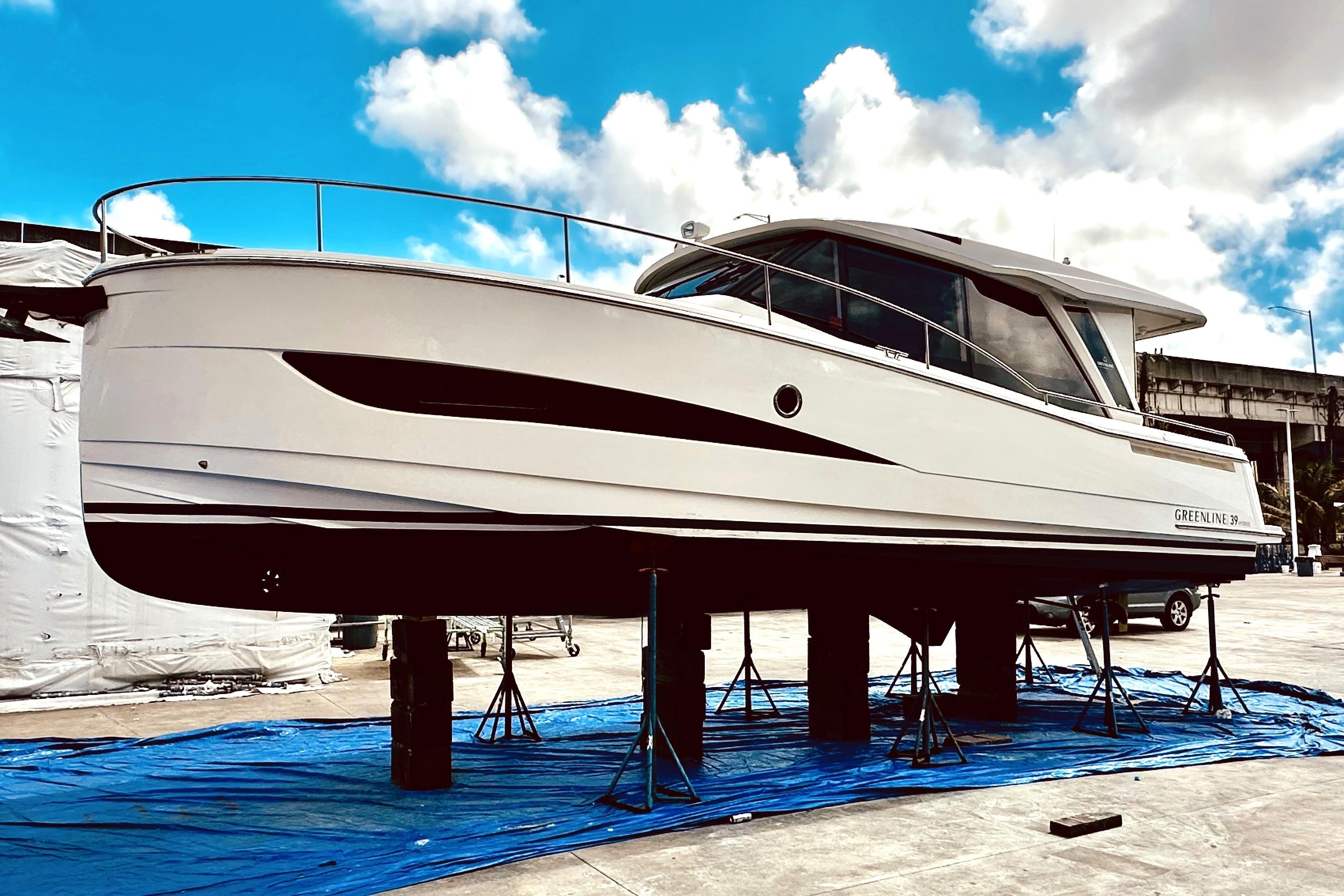 2021 Greenline 39 Hybrid yacht on stands, showcasing sleek design under a blue sky.