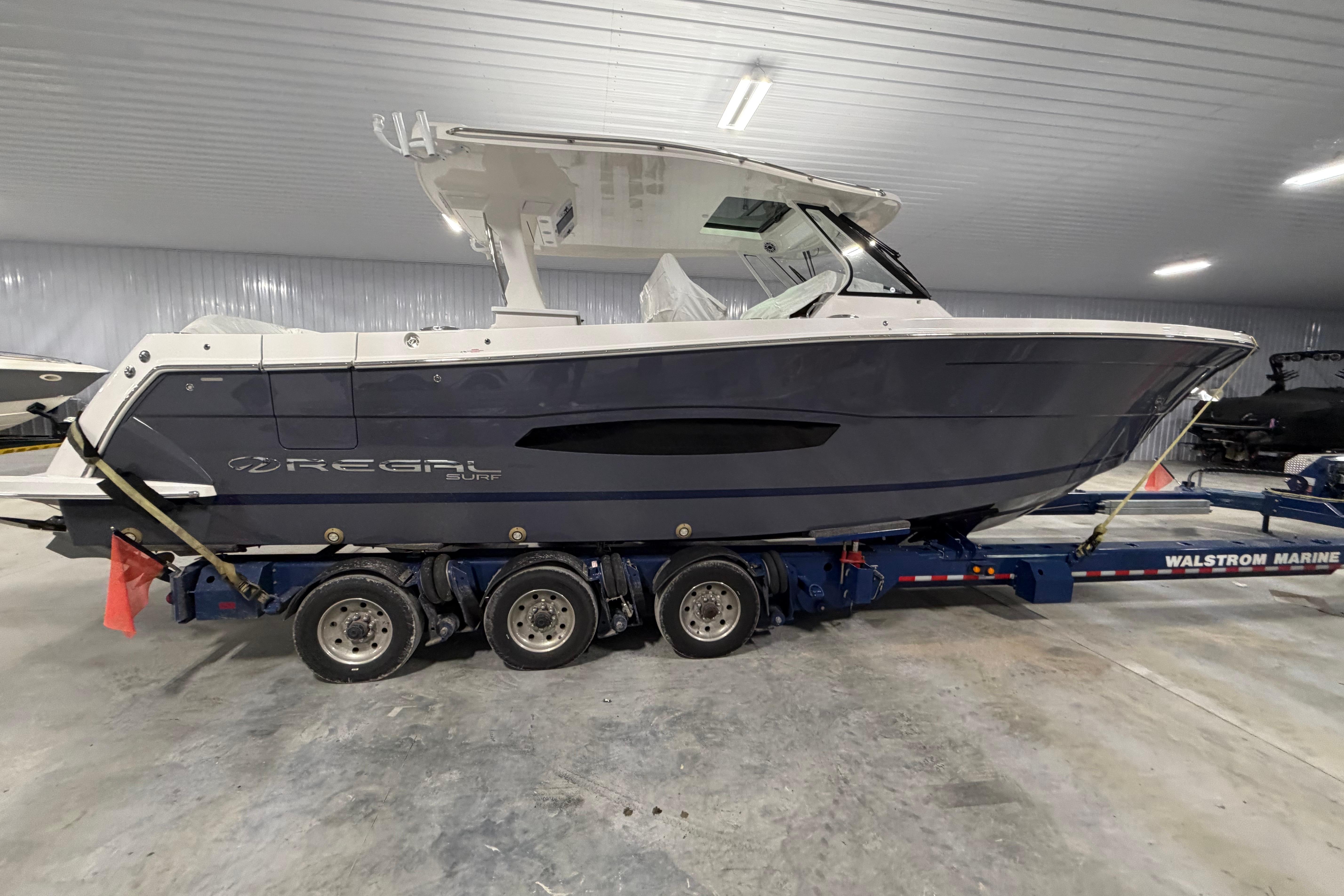 2027 Regal 38 Surf boat on trailer in indoor storage facility.