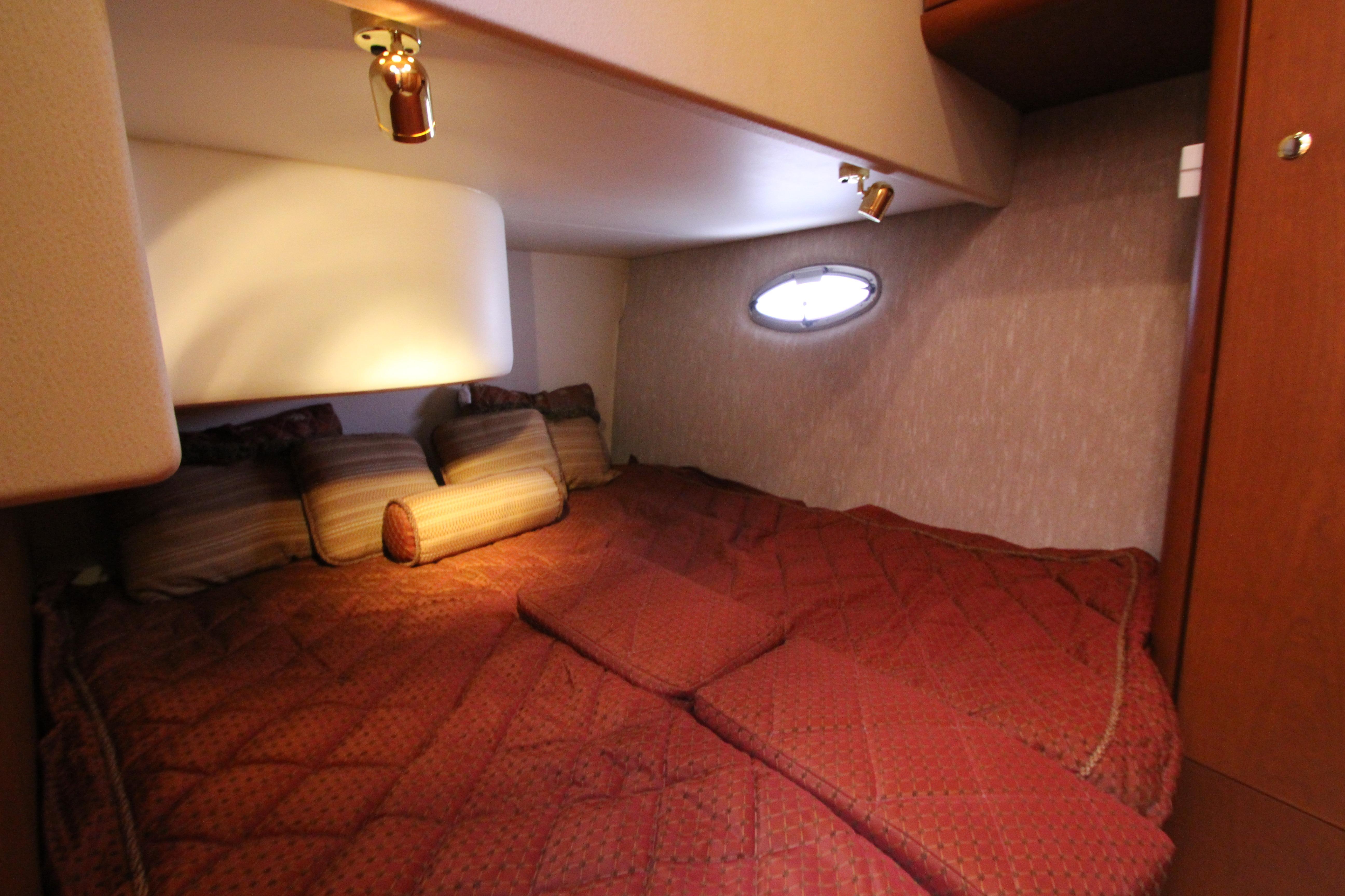 Cozy cabin interior of 2006 Silverton 38 Sport Bridge with plush bedding and ambient lighting.