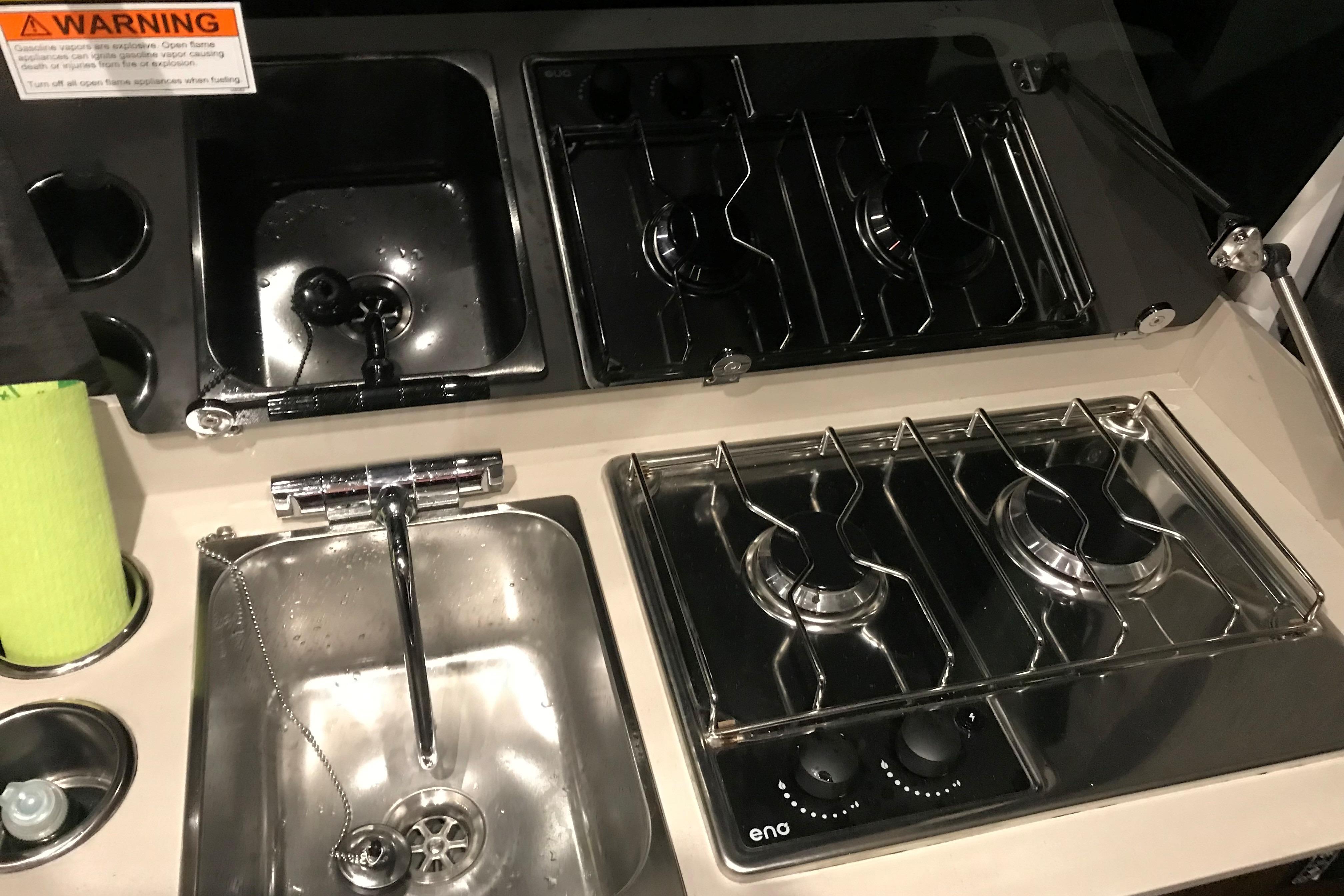 Compact kitchen area in 2024 Beneteau Antares 9 with stove and sink.
