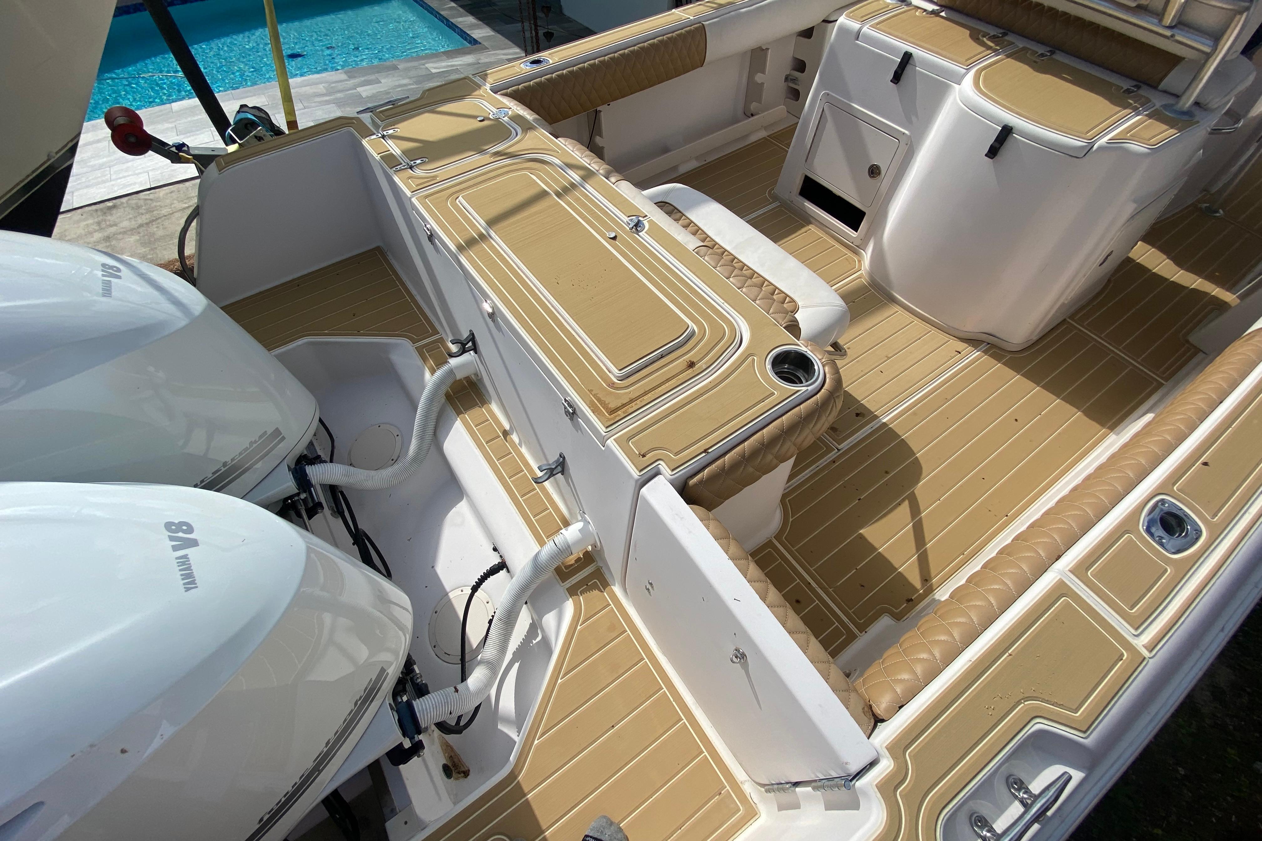 2004 Grady-White Canyon 283 boat interior with twin Yamaha engines, near a pool.