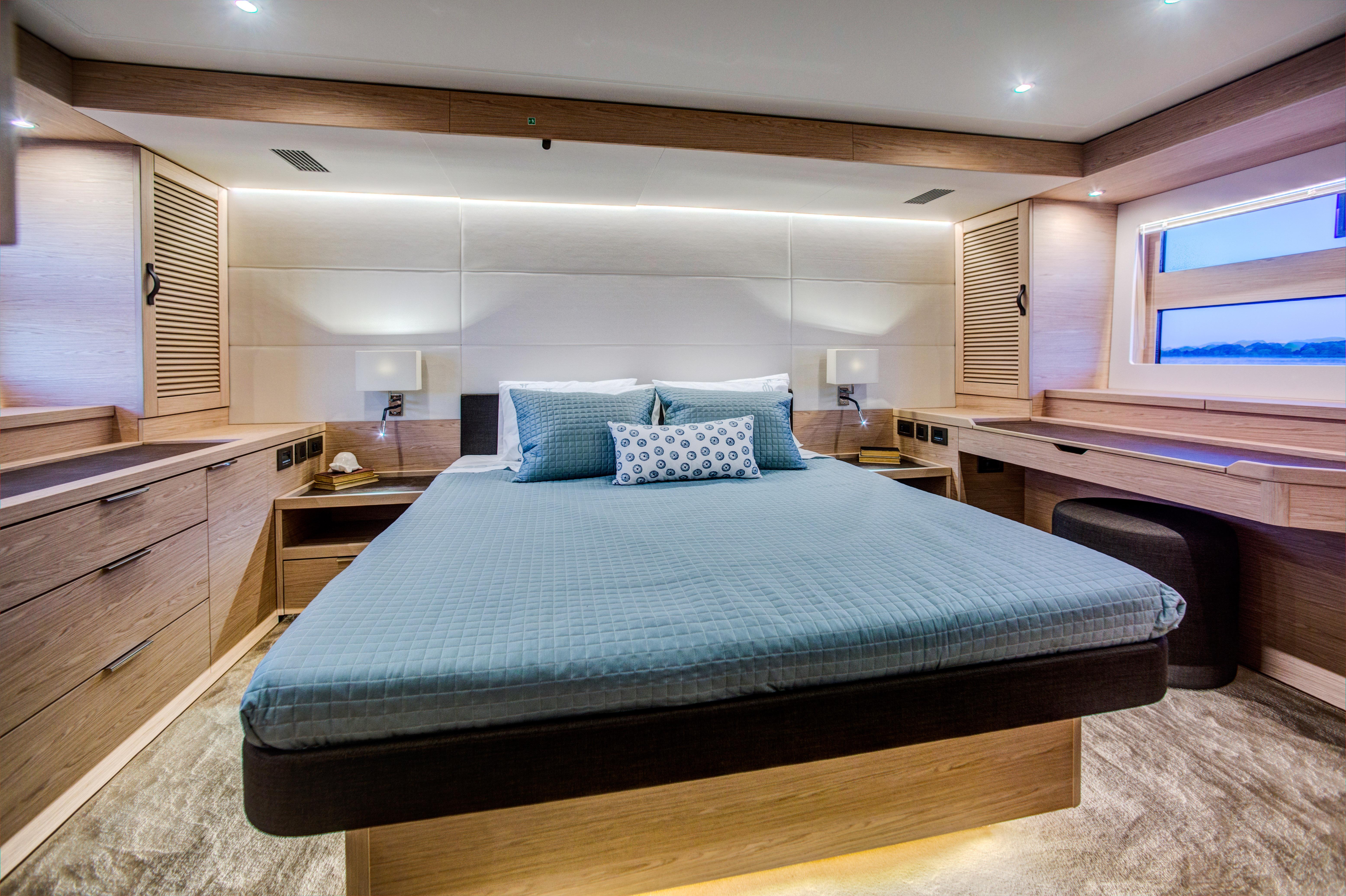 Luxurious bedroom in 2025 Beneteau Grand Trawler 62 yacht, featuring modern design and ambient lighting.