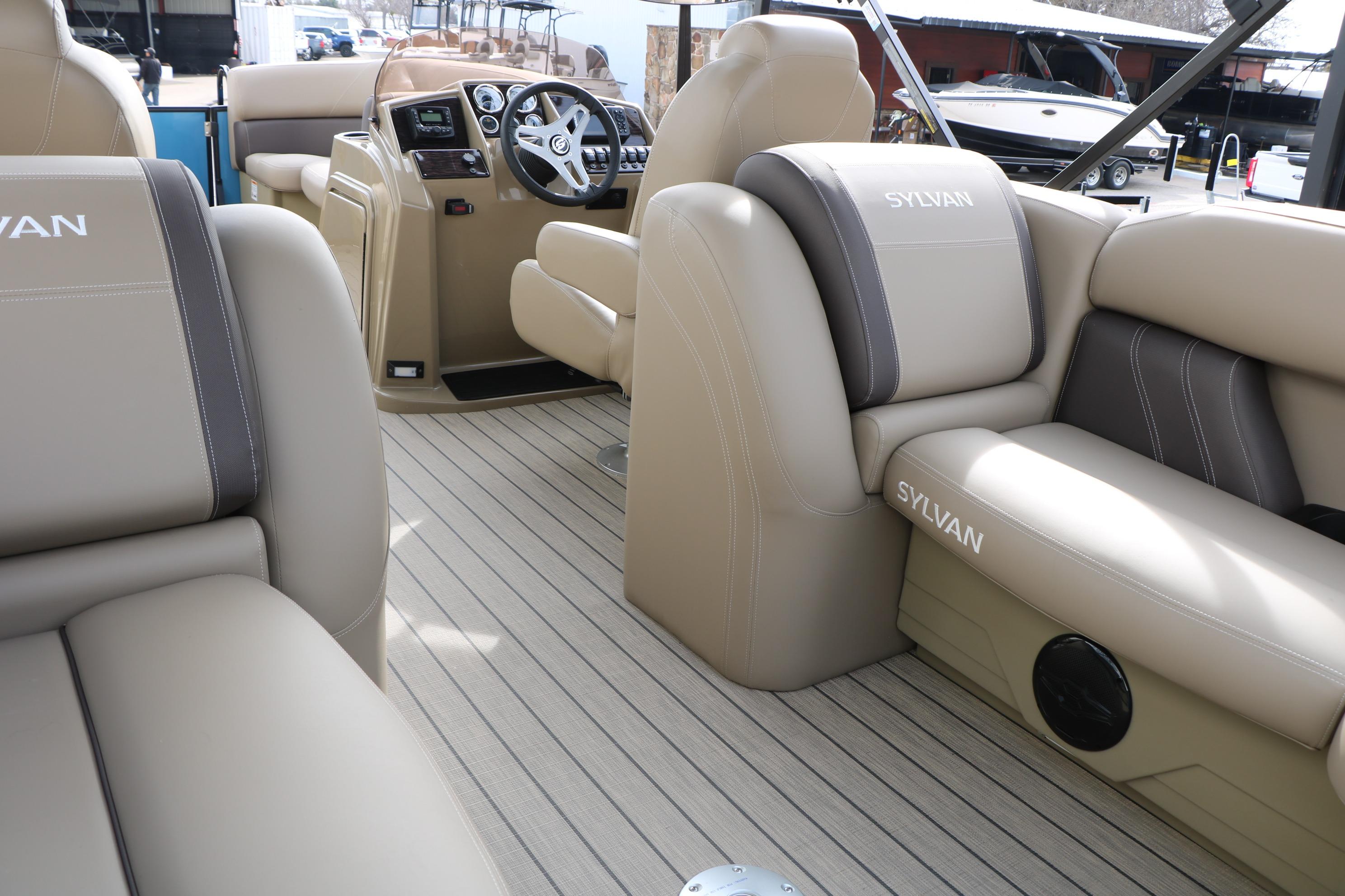 Interior of 2026 Sylvan Mirage 822 LZ pontoon boat with beige seating and steering console.