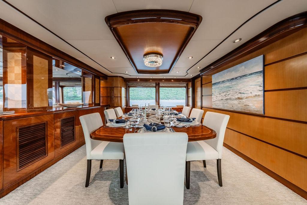 Luxurious dining area on 2012 Ares Custom Marine Custom 141 yacht, featuring elegant wood paneling.