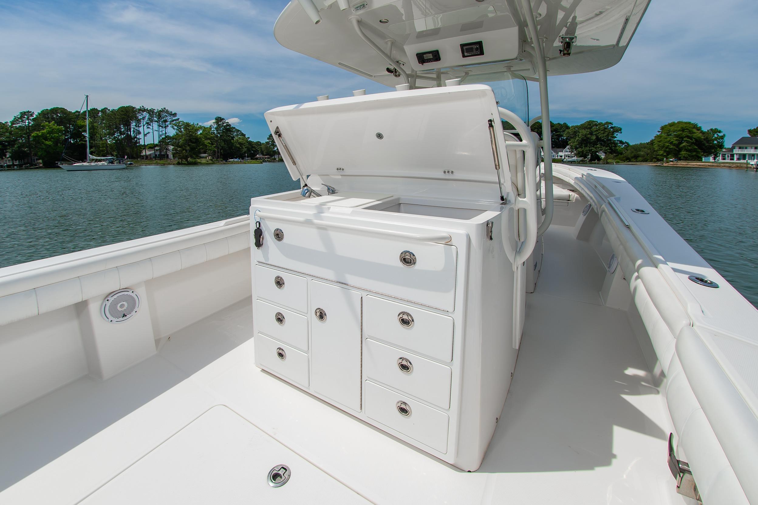 2019 Regulator 31 boat with open storage compartments on a calm lake.