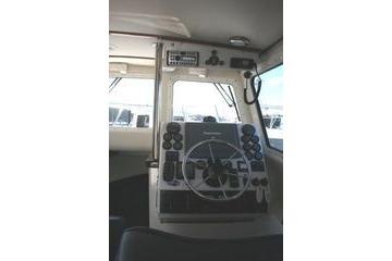 2005 Ocean Sport Roamer 30' boat cockpit with steering wheel and control panel.