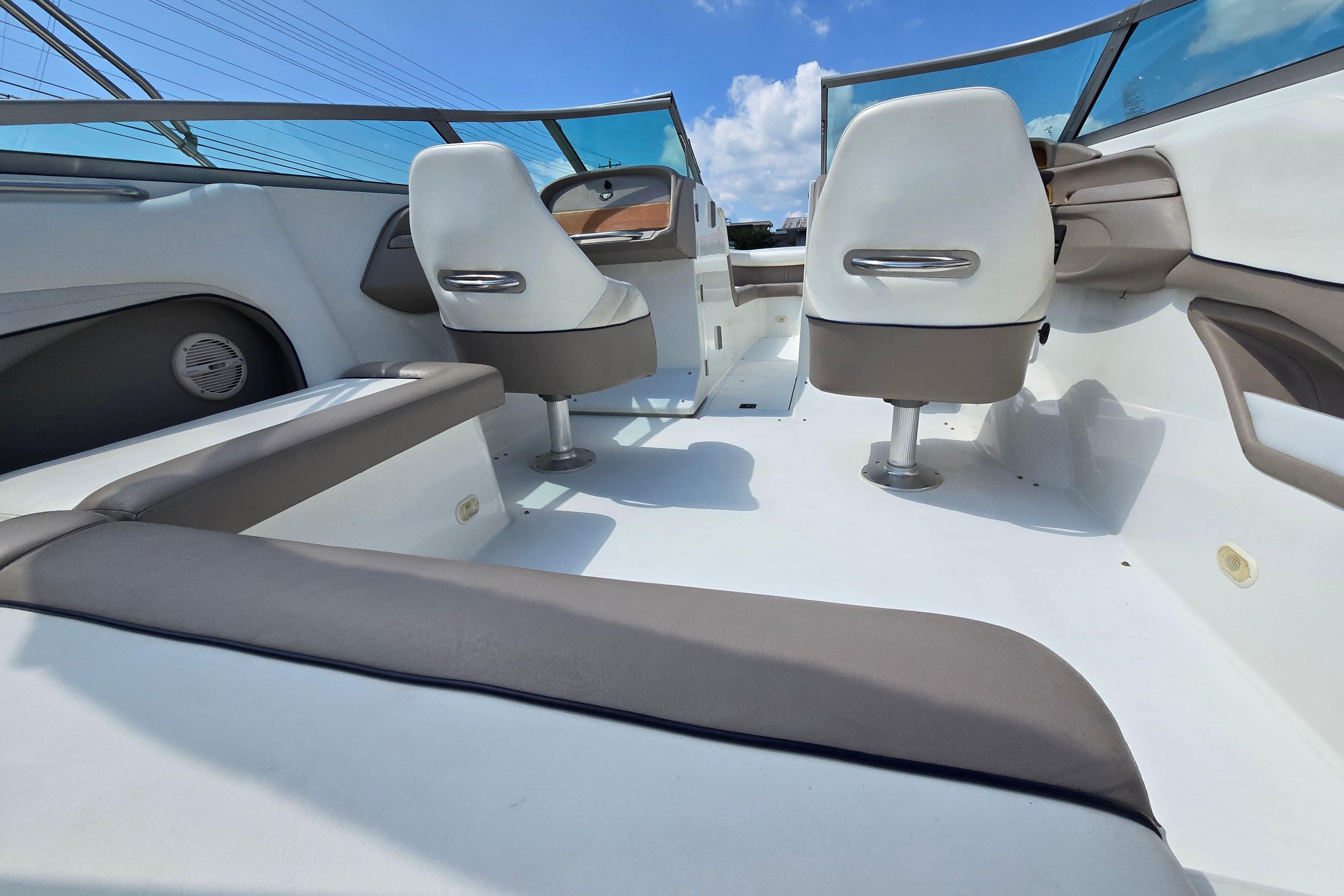 Interior of a 2000 Cobalt 246 boat with white seating and blue sky background.