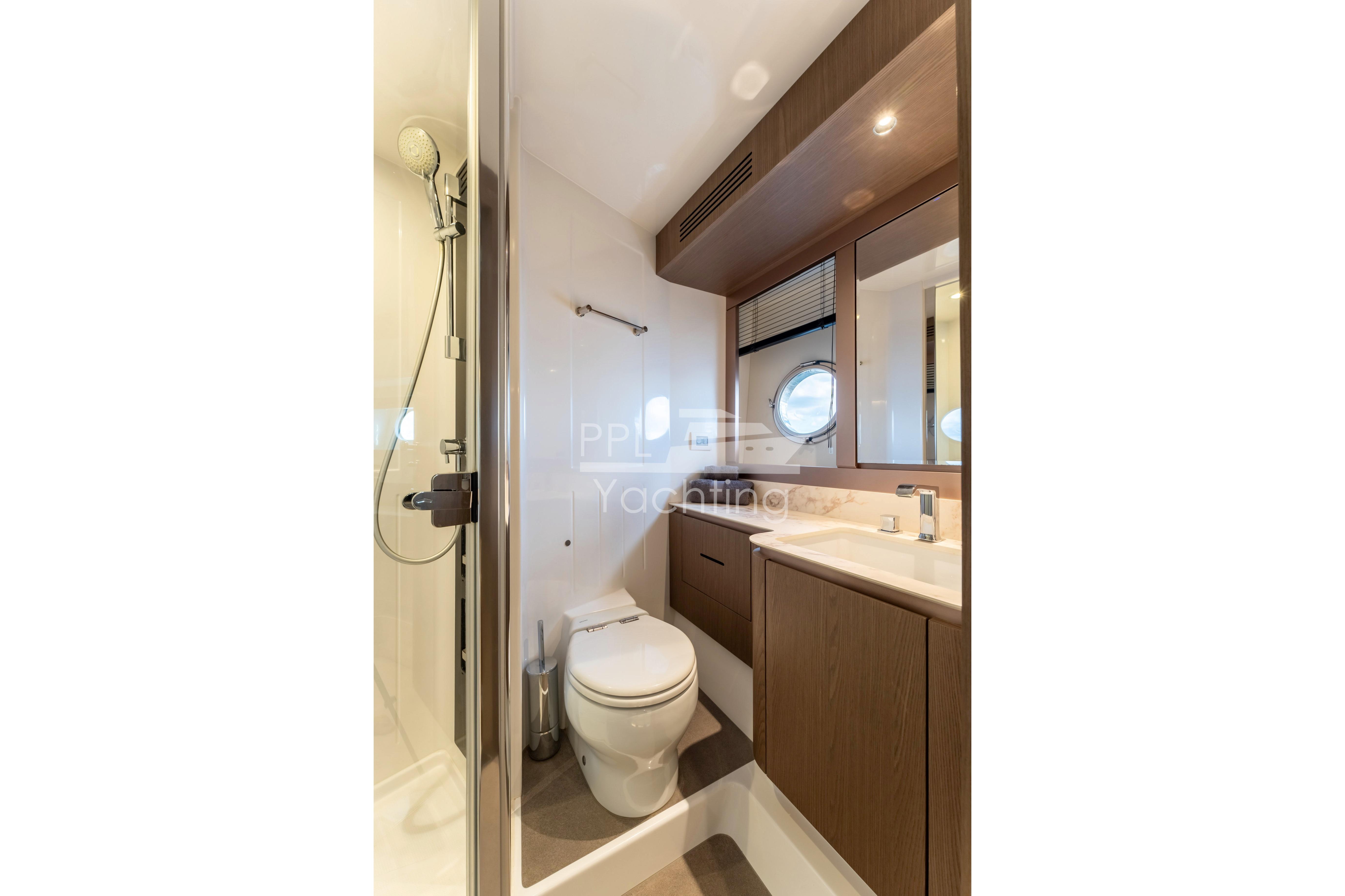 Bathroom interior of 2021 Azimut Magellano 66 yacht, featuring modern fixtures and elegant design.