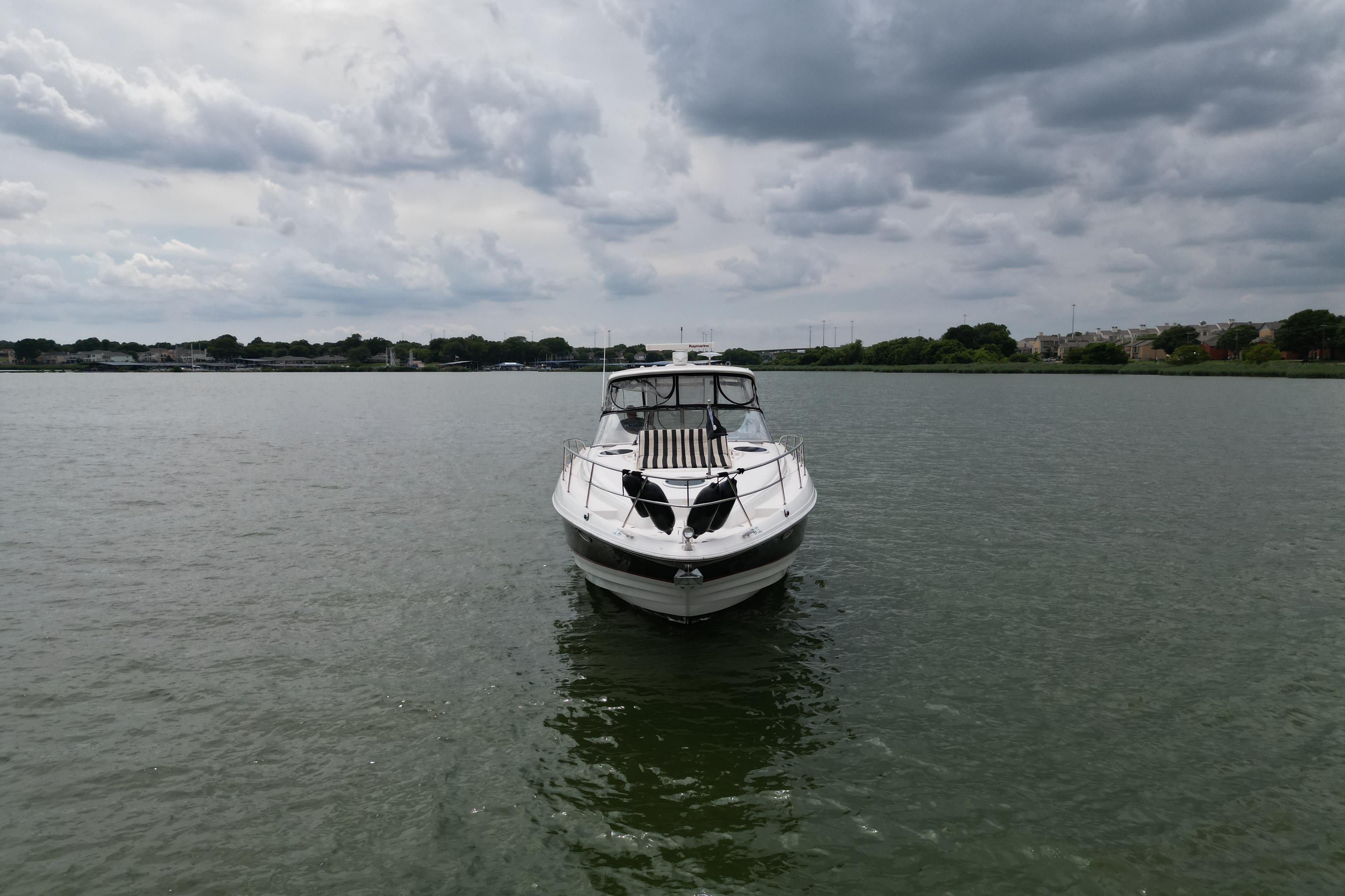 2005 Regal Commodore 4260 yacht on calm water under cloudy sky.