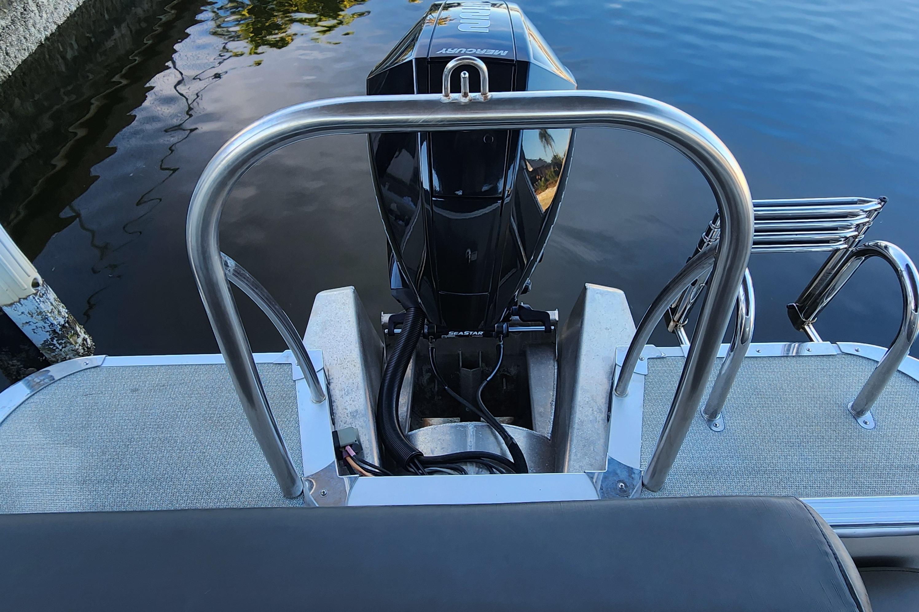 2022 Tahoe Tritune 2585 ENT boat with outboard motor and stainless steel railing.