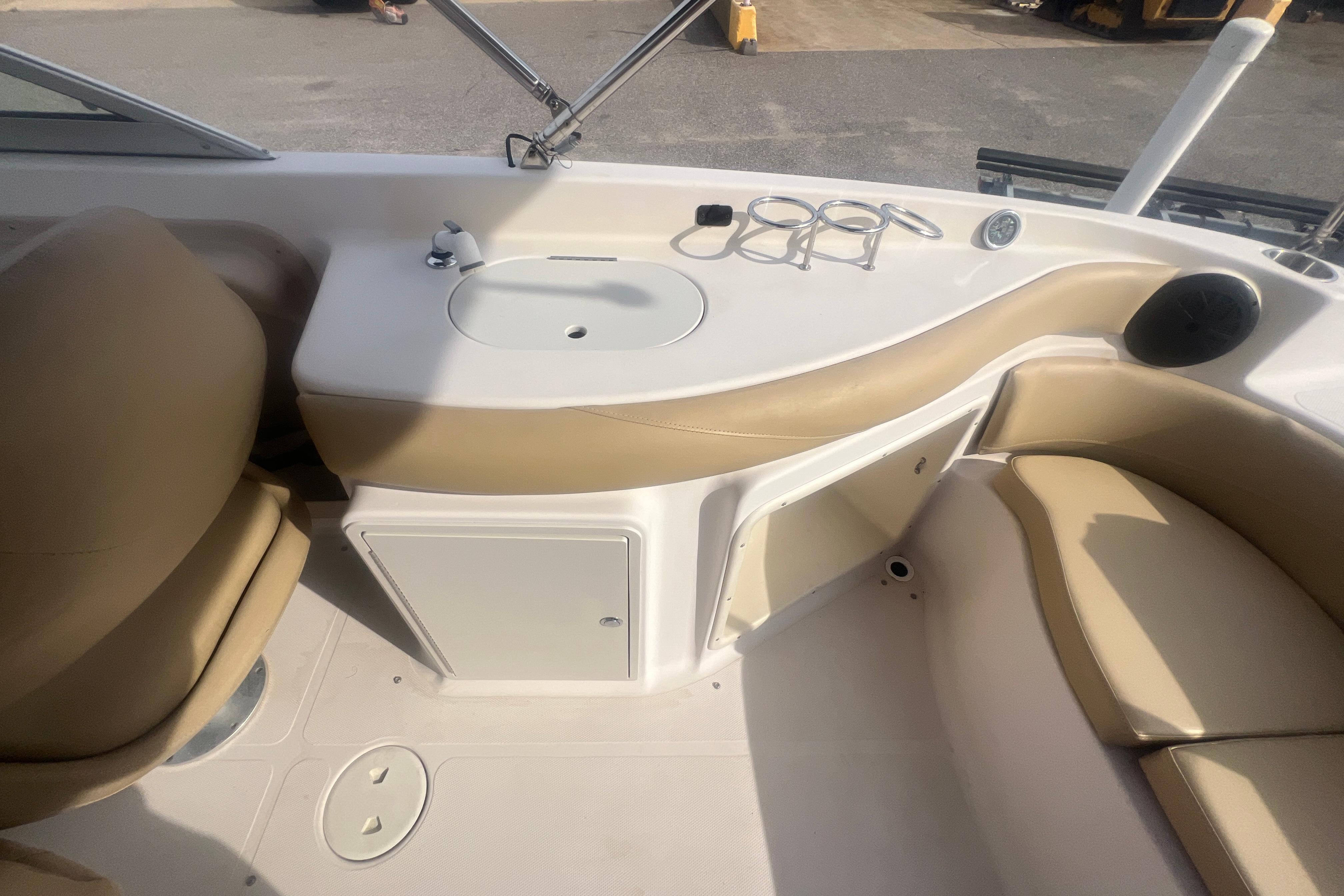 2002 Hurricane SunDeck 260 OB boat interior with sink, seating, and storage.