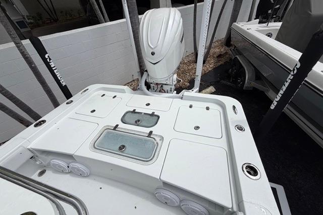 2025 Contender 26 Bay boat deck with storage compartments and outboard motor.