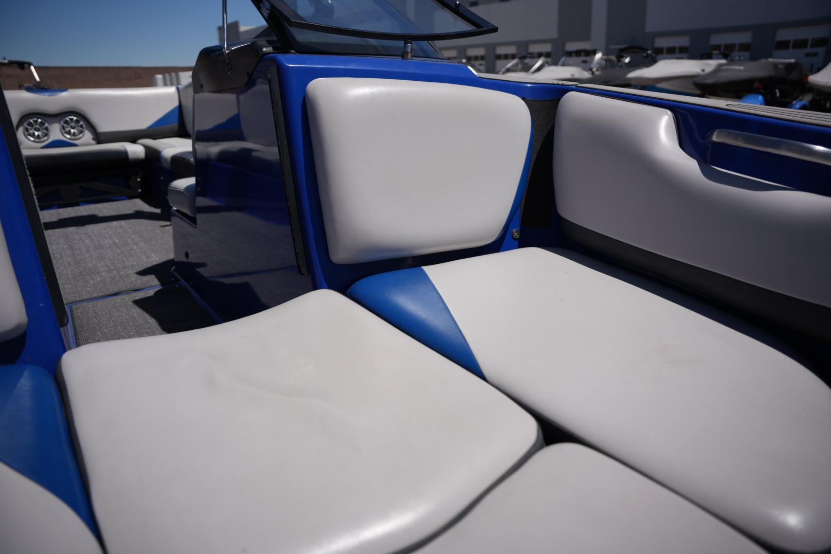 2015 Axis A24 boat interior with blue and white seating under clear sky.