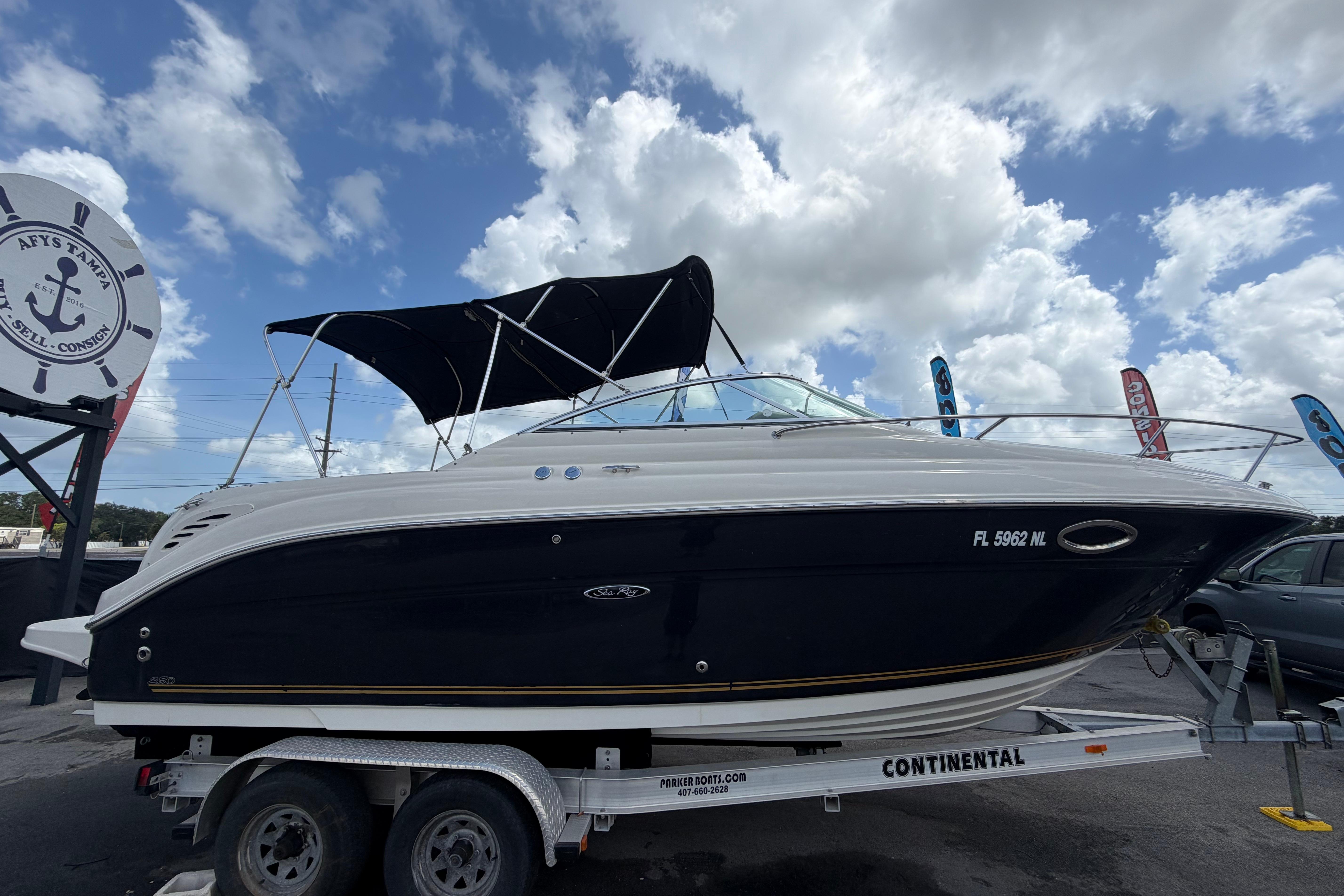 2006 Sea Ray 250 Amberjack boat on trailer under cloudy sky.
