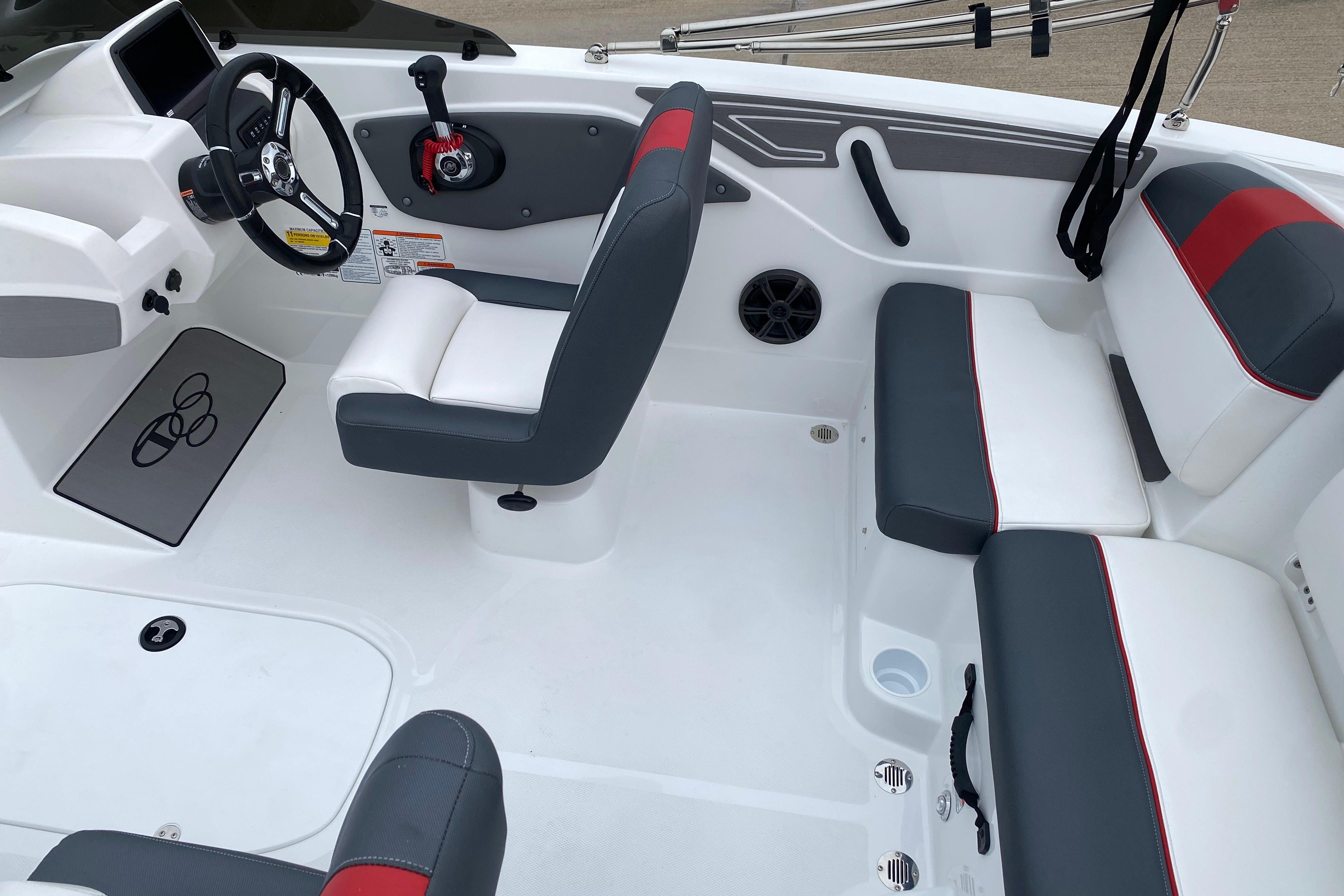 2026 Tahoe T21 boat interior with gray and red seating, steering wheel, and control panel.