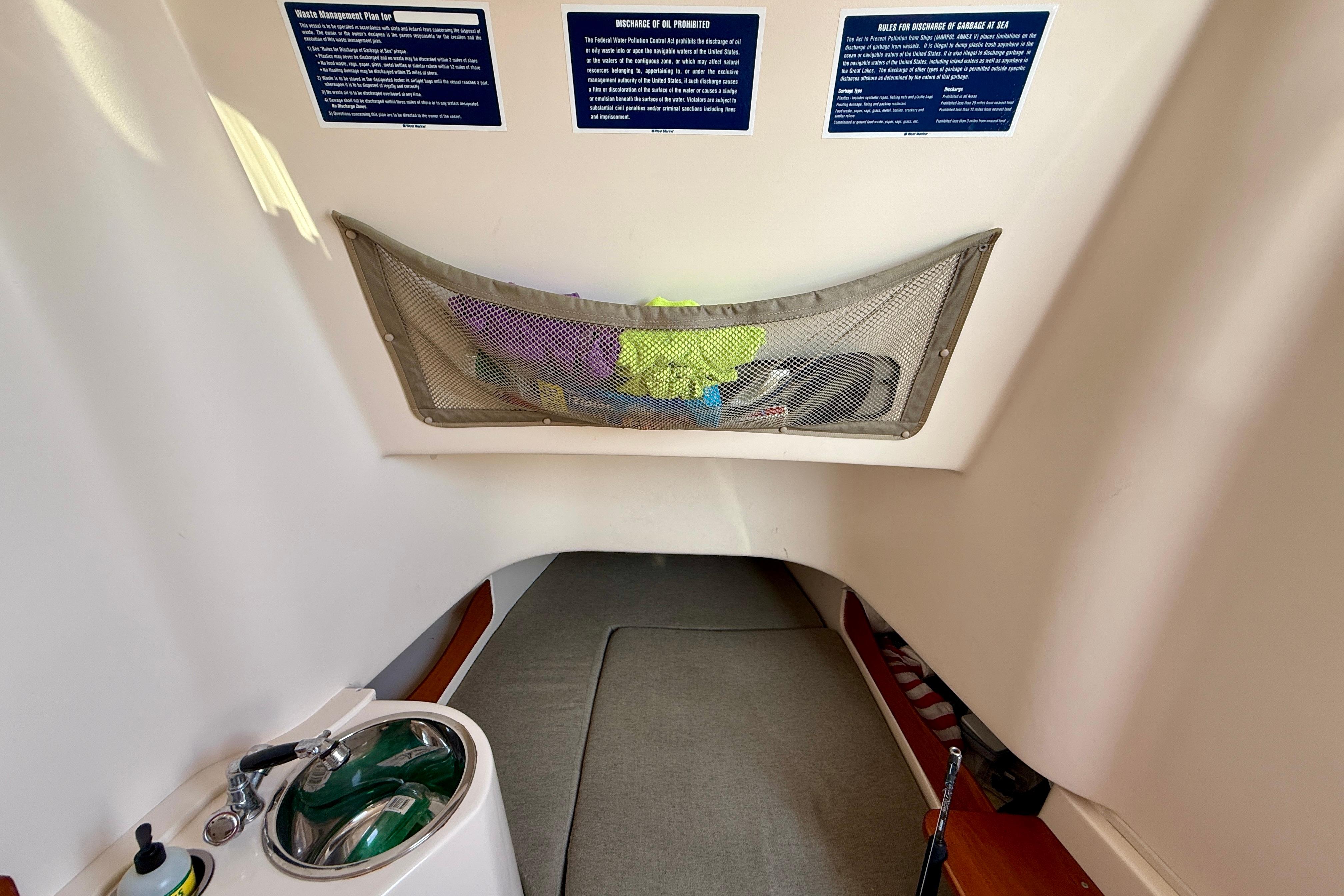 Interior cabin of 2012 Grady-White Canyon 336 boat with sink and storage net.