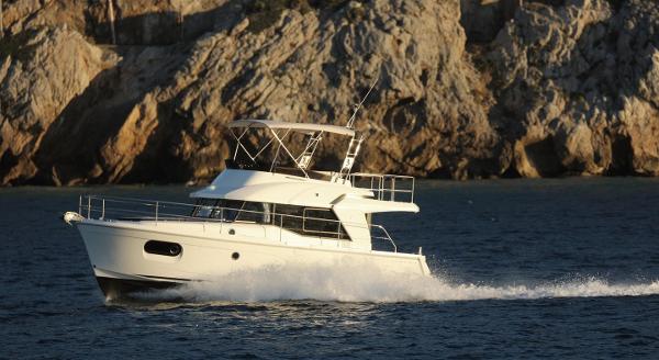 2021 Beneteau Swift Trawler 35 cruising near rocky coastline.