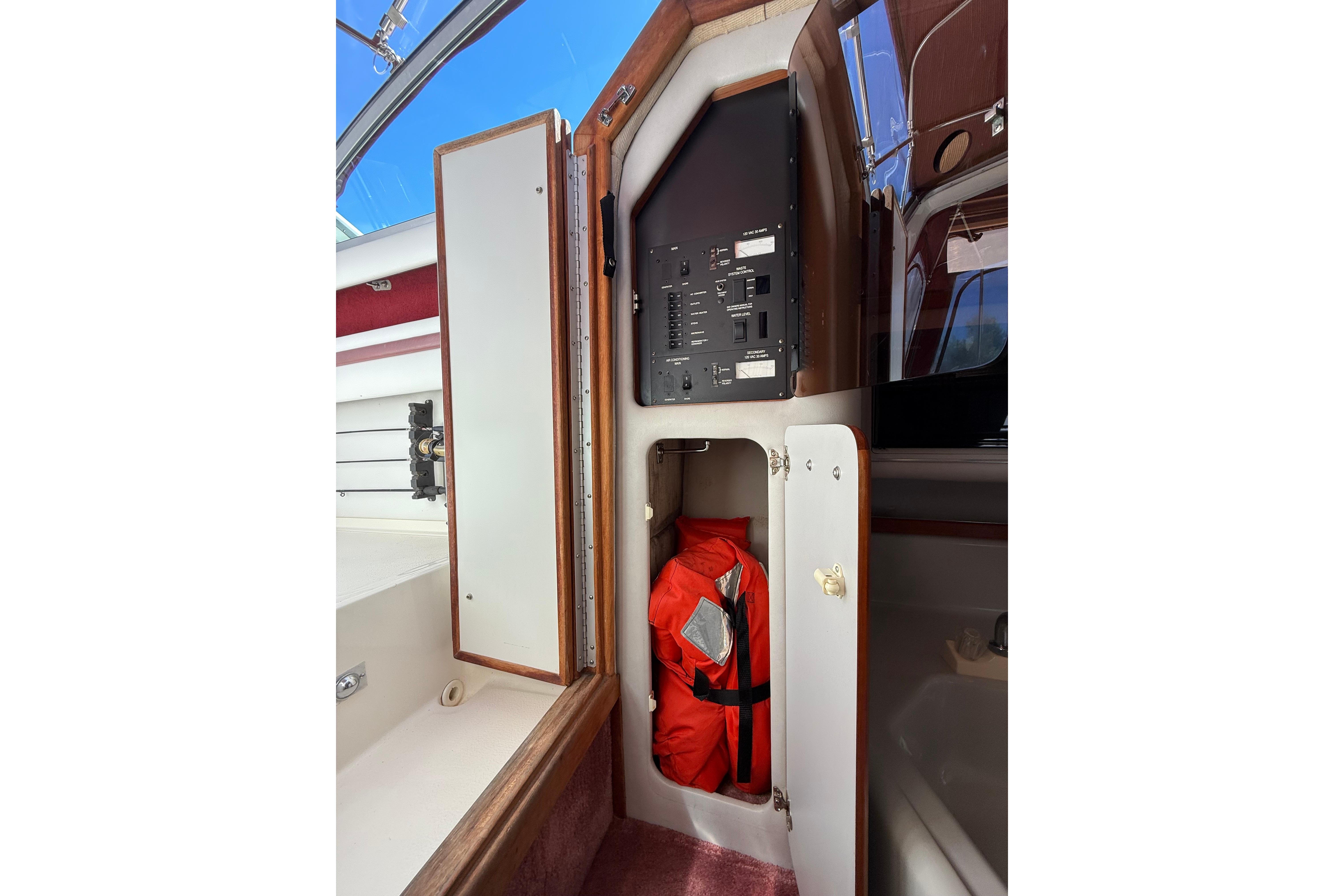 1990 Sea Ray 310 Express Cruiser interior with control panel and life jacket storage.