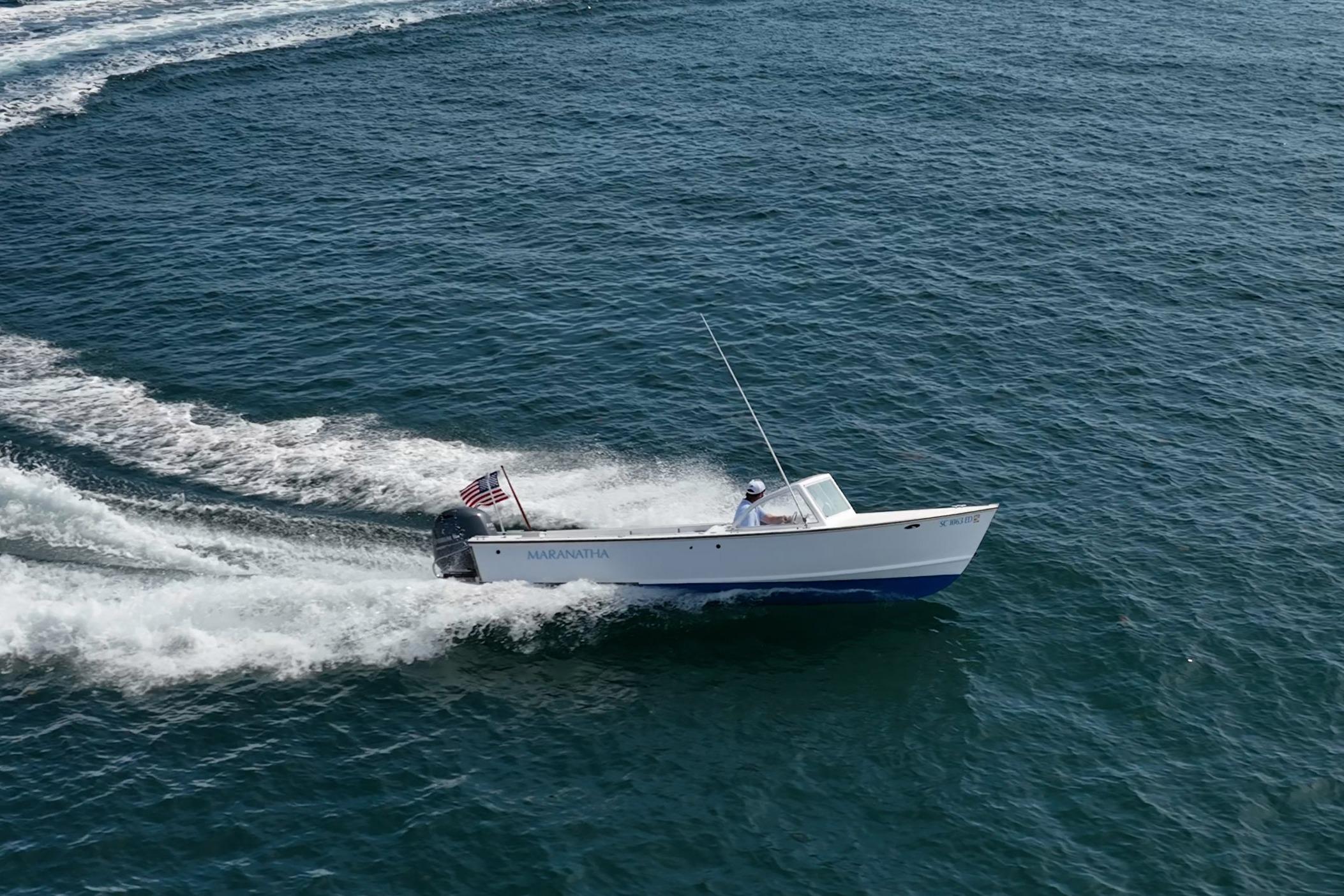 1982 Albury Brothers Runabout cruising on open water with American flag.