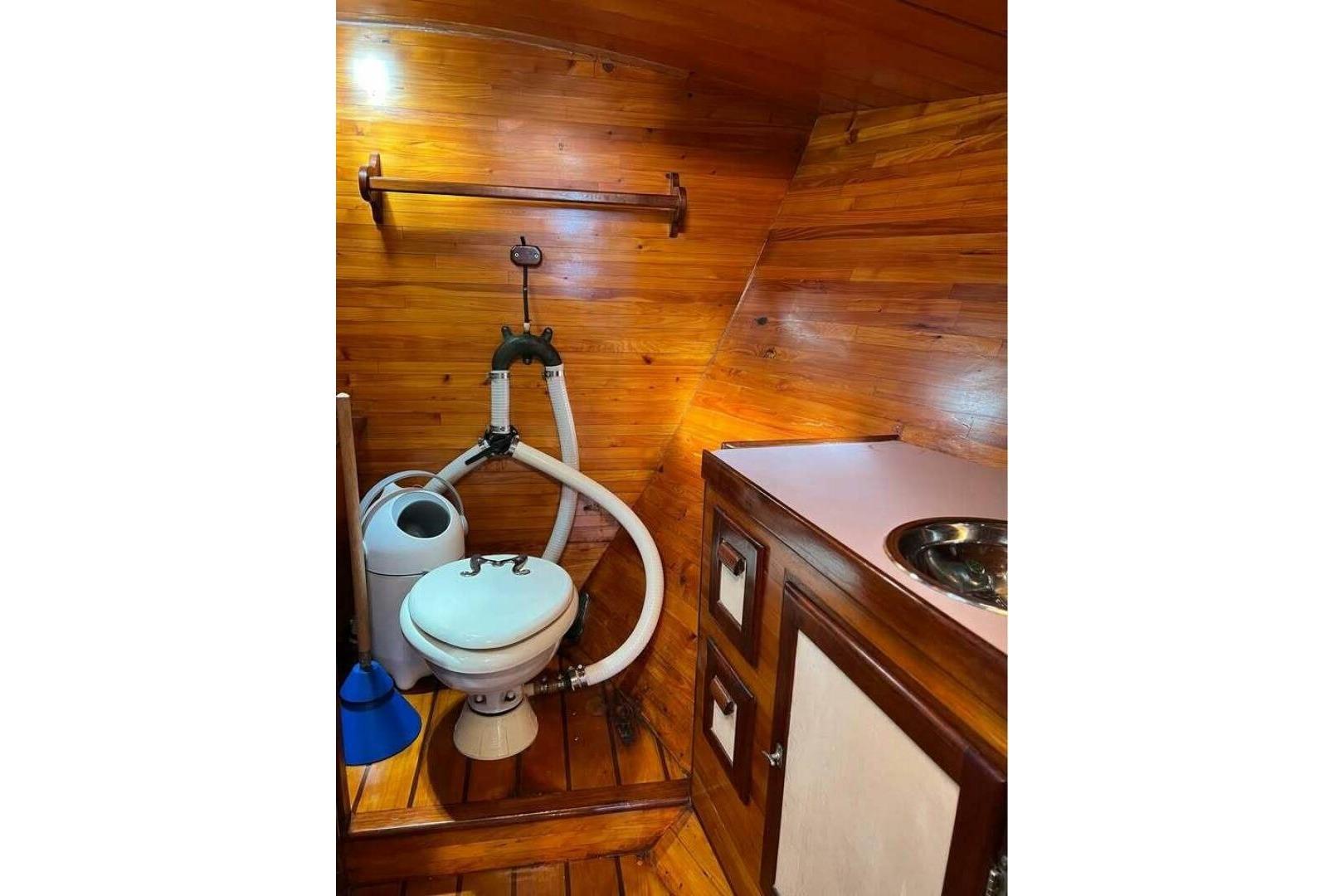 Wood-paneled bathroom in 1993 Custom Baraka 46 boat with toilet and sink.