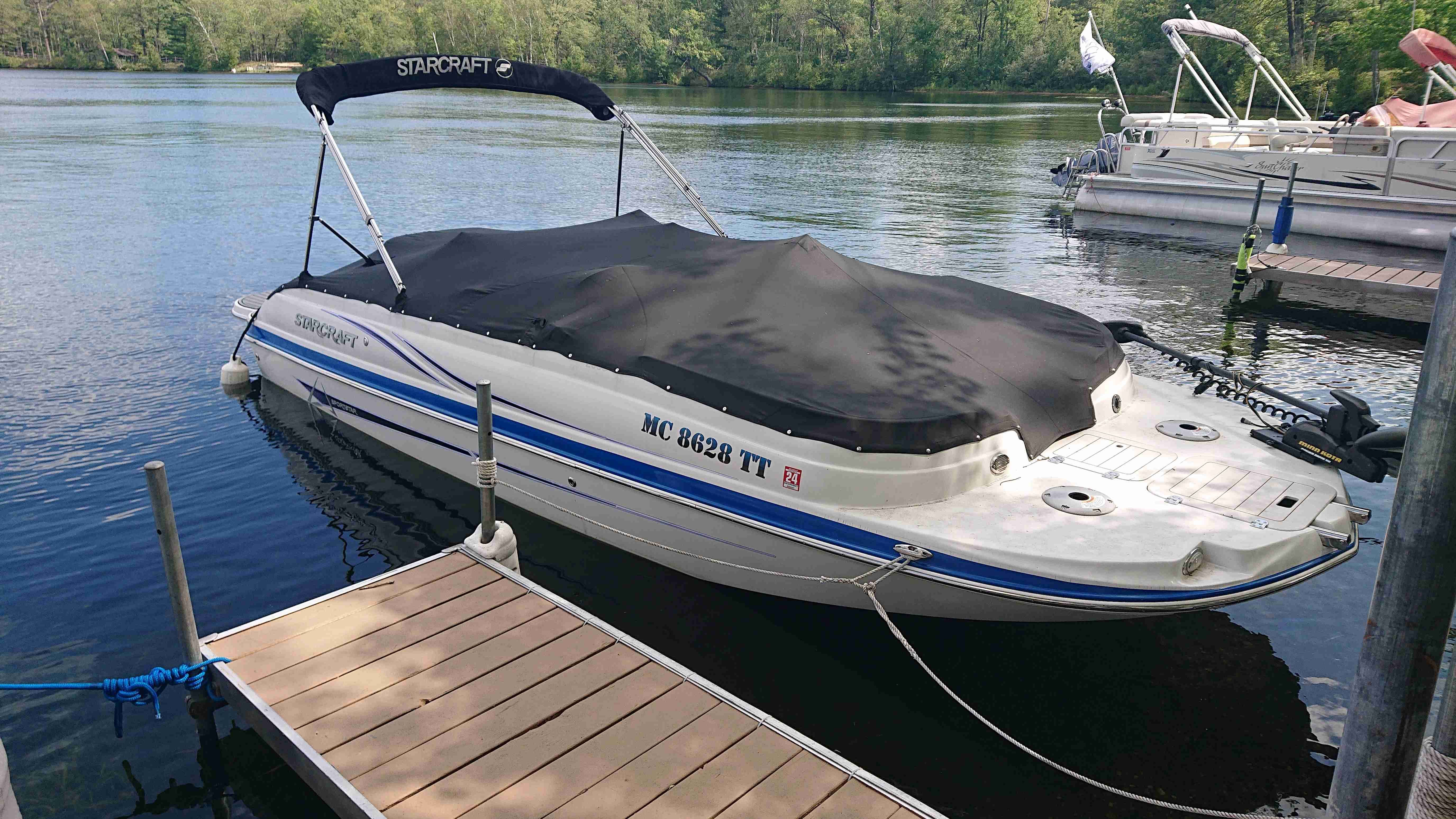 2015 Starcraft 2000 boat docked on calm water.