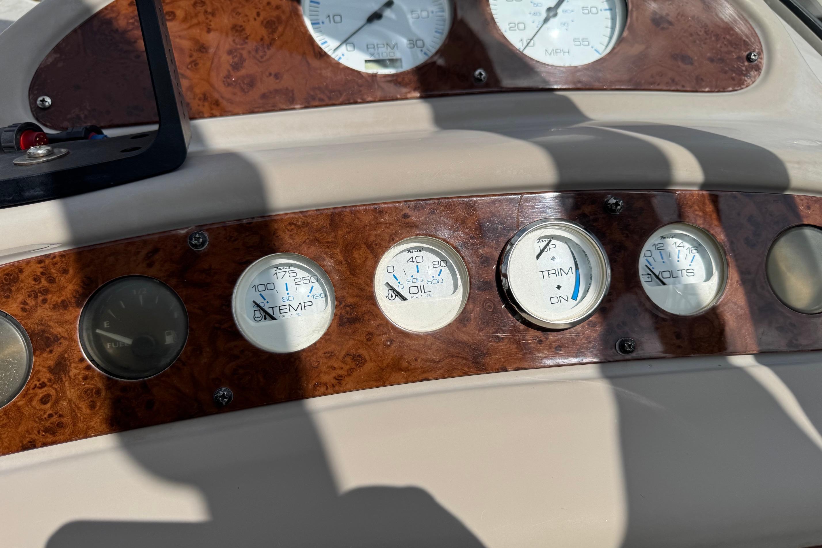 Dashboard of a 2000 Maxum 2400 SCR boat with temperature, oil, trim, and volt gauges.