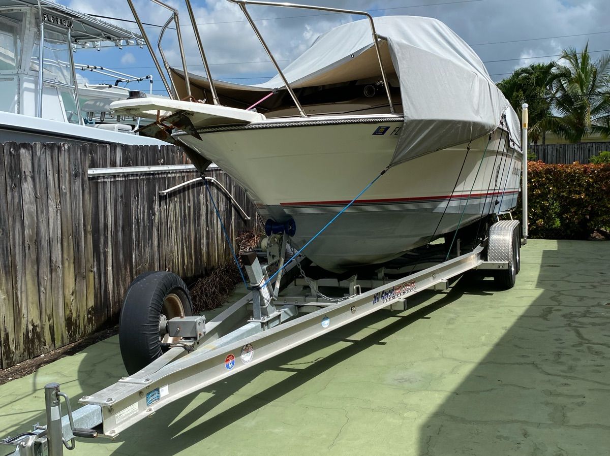 1990 Bayliner 2302 Trophy on trailer, covered, outdoors.