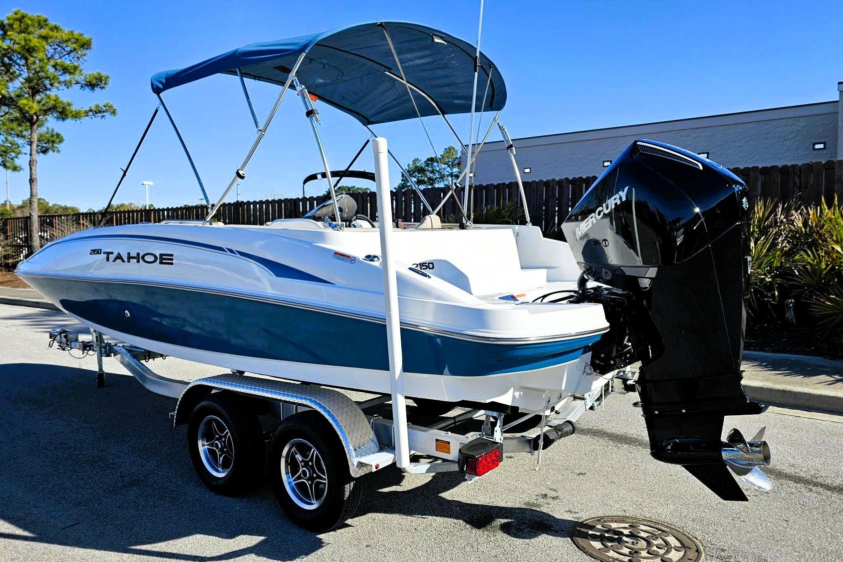 2026 Tahoe 2150 boat with Mercury outboard engine on a trailer, parked outdoors.
