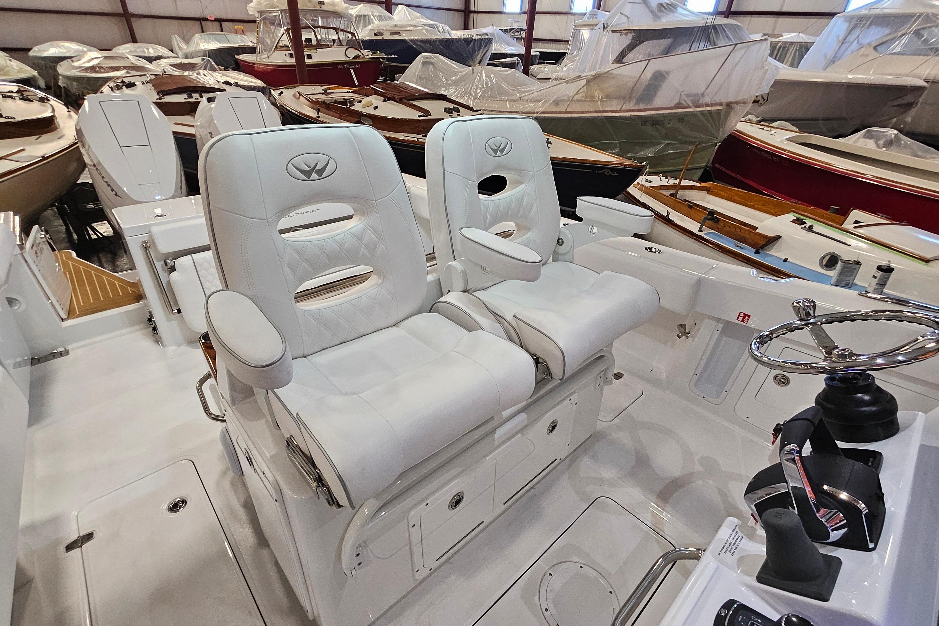 2026 Southport 30 FE boat interior with white leather seats and steering wheel in a showroom.