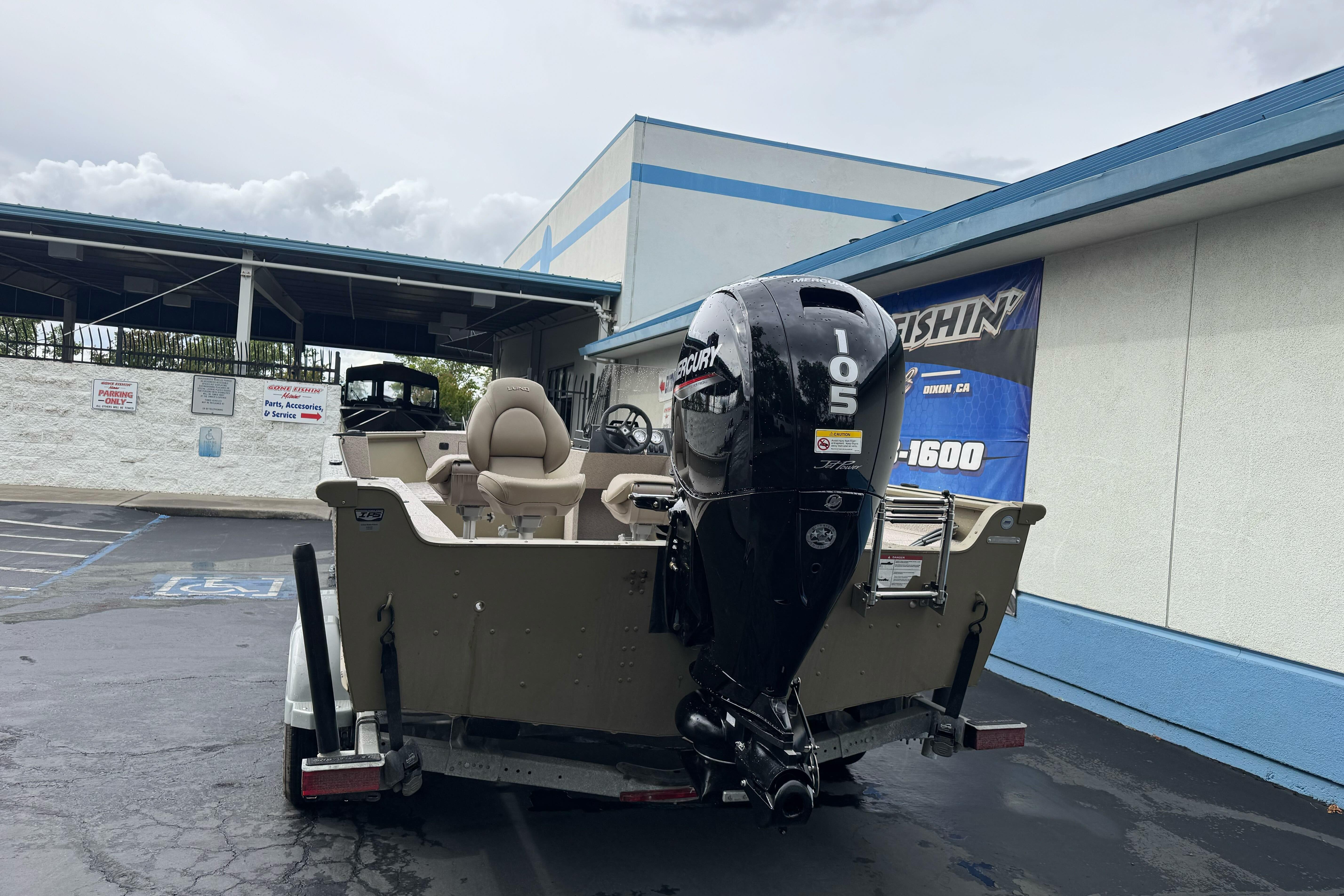 2026 Lund 2075 Alaskan SS boat with Mercury 105 engine in parking lot.