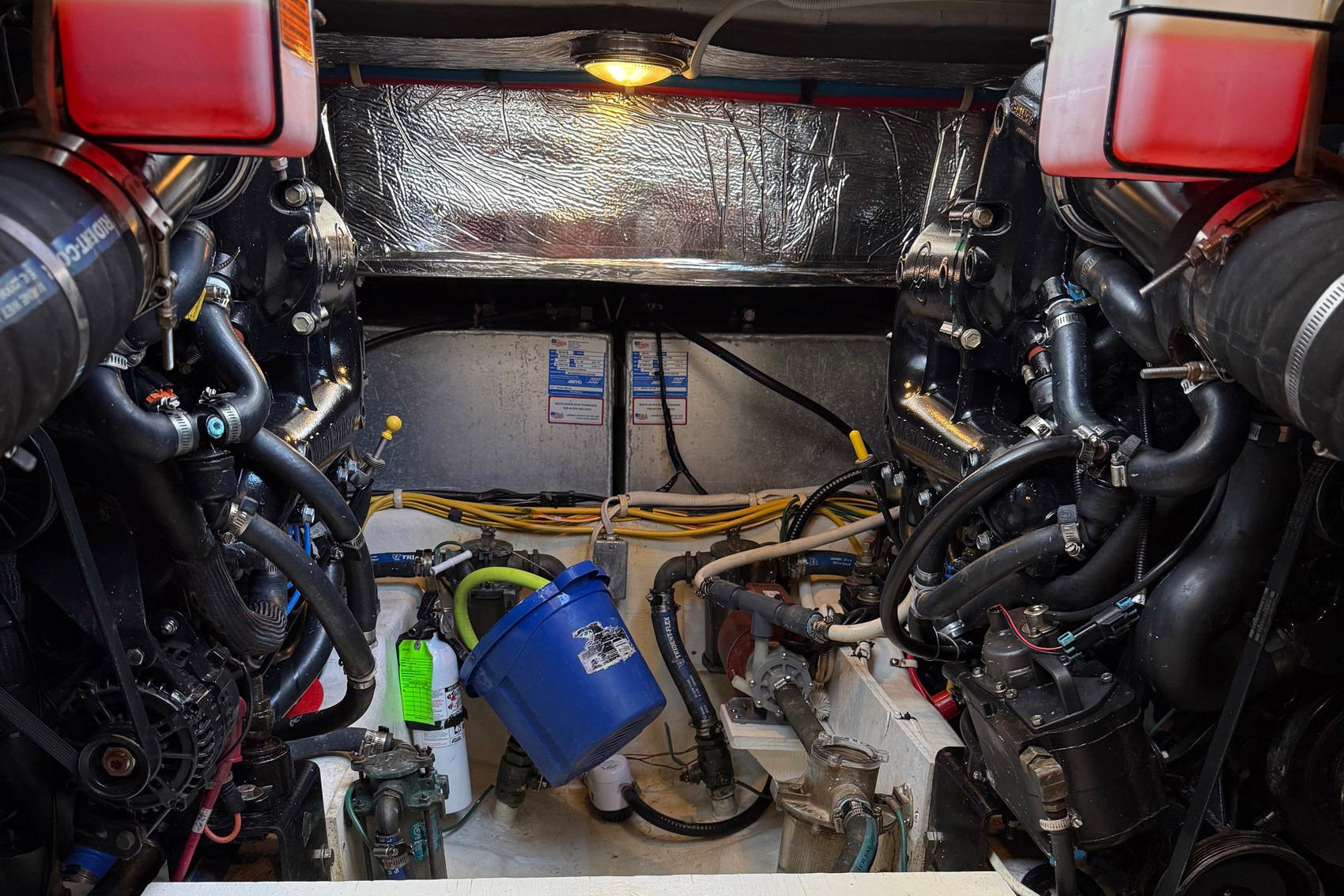 Engine room of a 2013 Carver C34 boat, showcasing complex machinery and components.