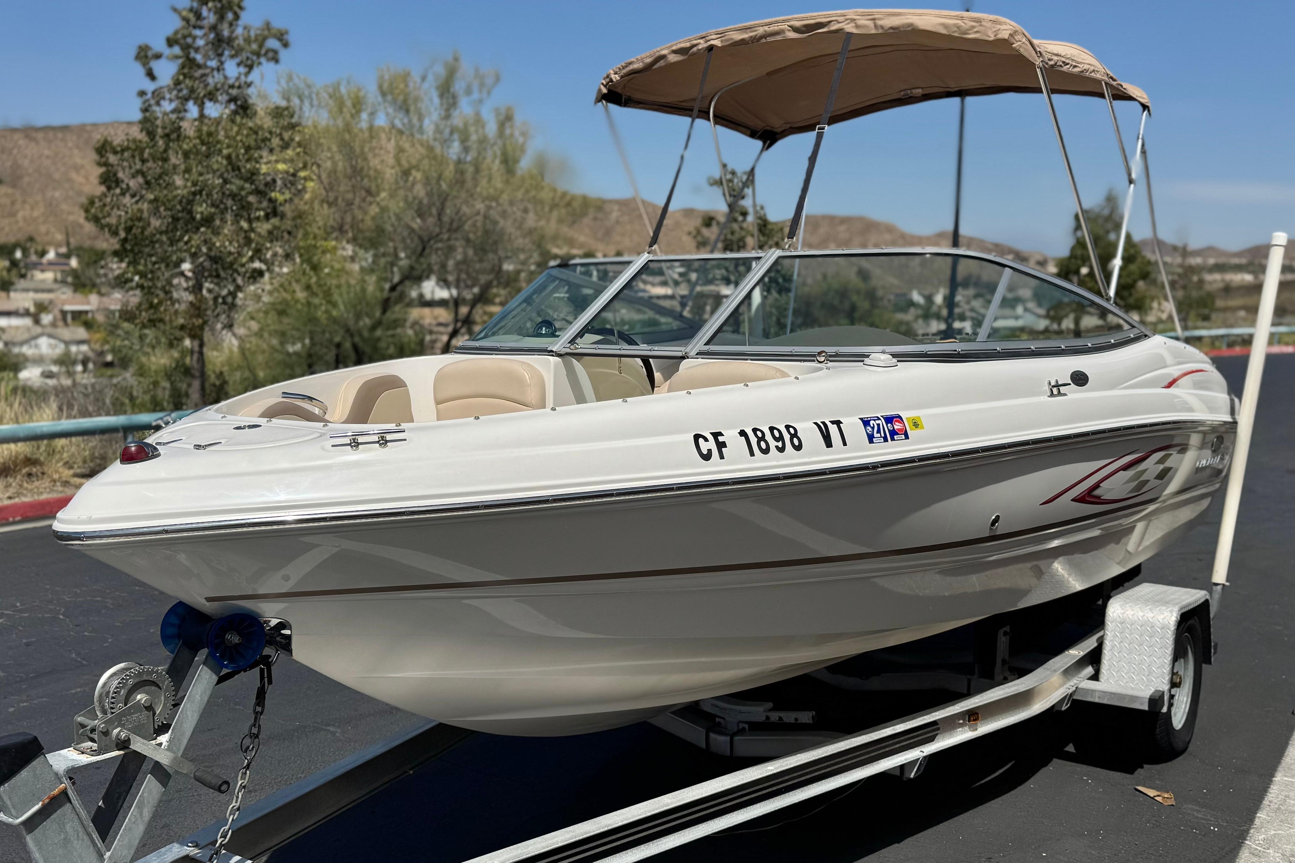 2006 Chaparral 190 SSi boat on trailer with canopy, parked outdoors.