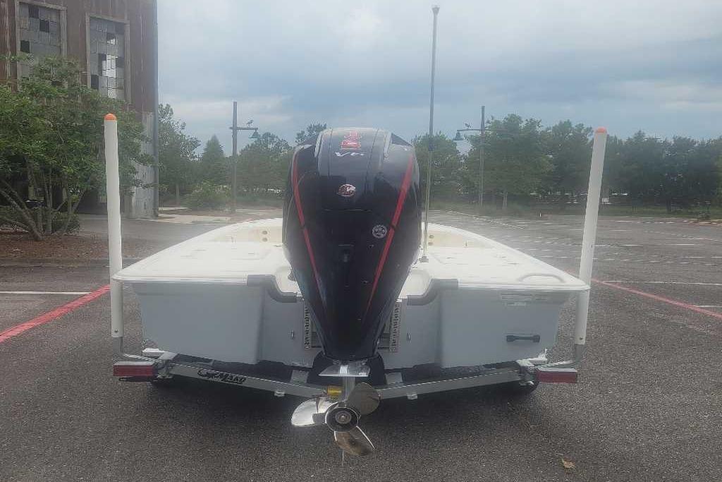 2026 Mako 18 Pro Skiff boat on trailer, rear view in parking lot.