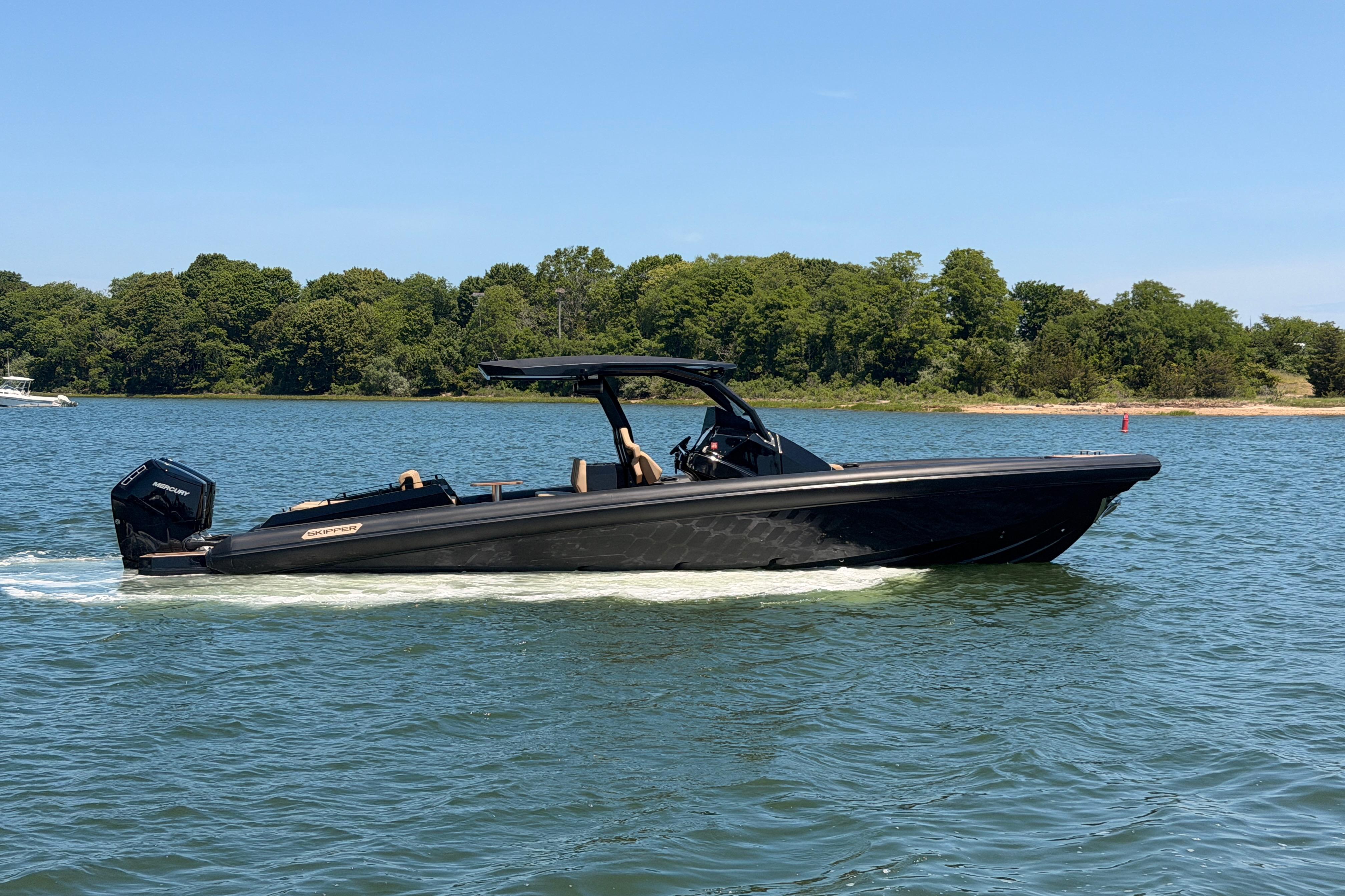 2023 Skipper-BSK 42NC boat cruising on a serene lake with lush green shoreline.