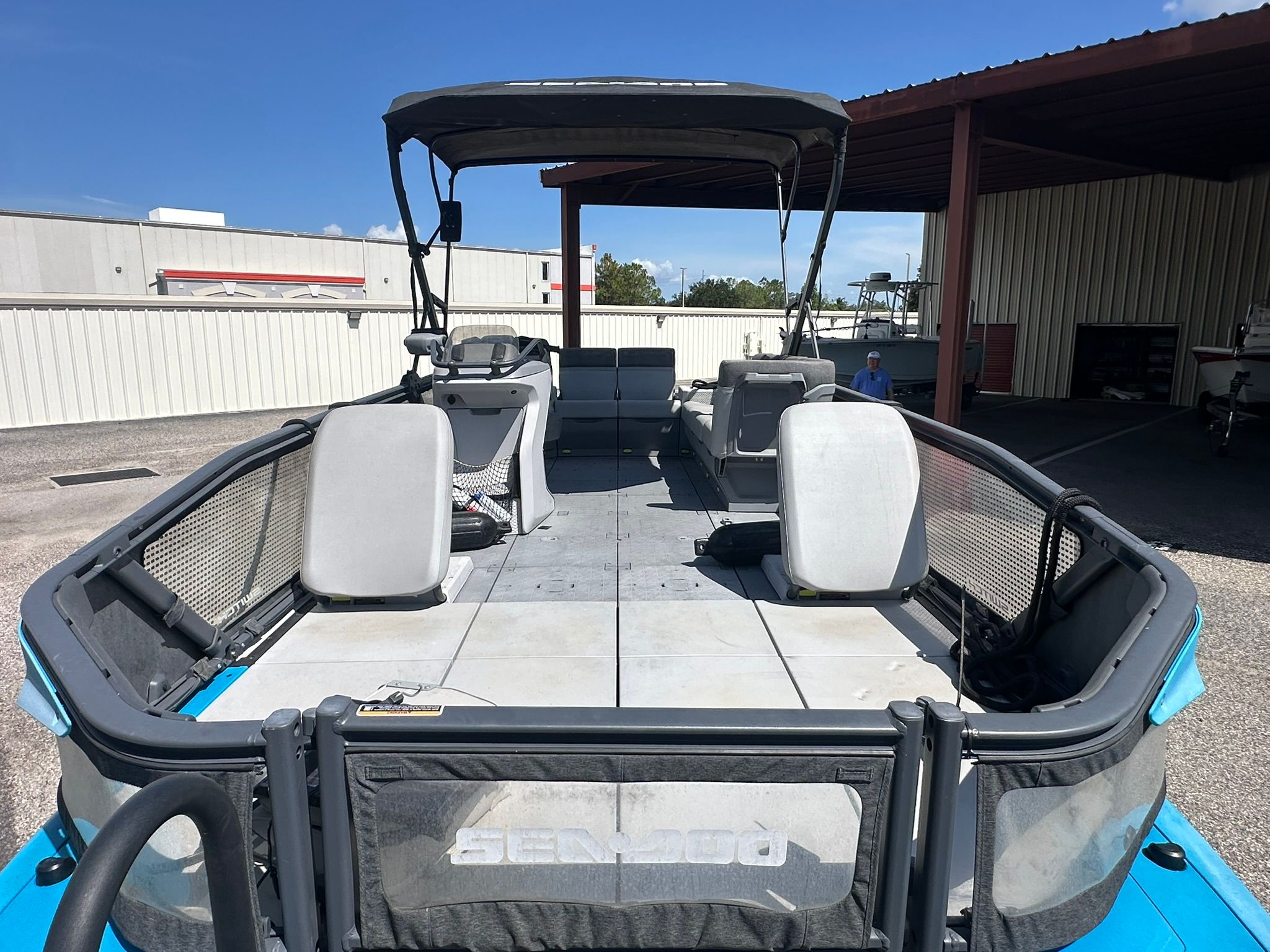 Sea-Doo 21 SWITCH SPORT 2023 with spacious deck and seating, parked in a covered area.