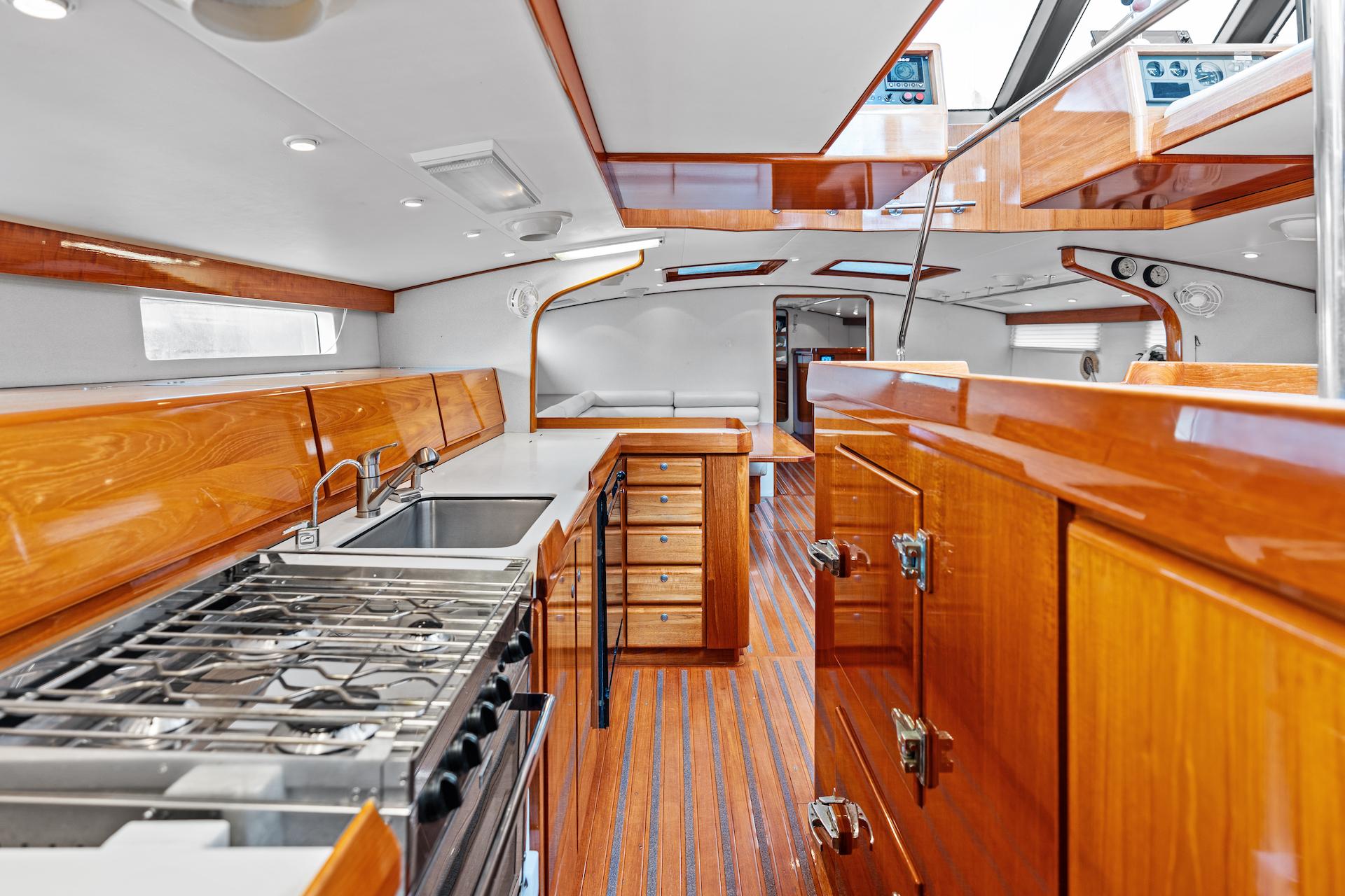 Luxurious 1998 Custom Kelly Archer yacht interior with sleek wood finishes and modern kitchen amenities.