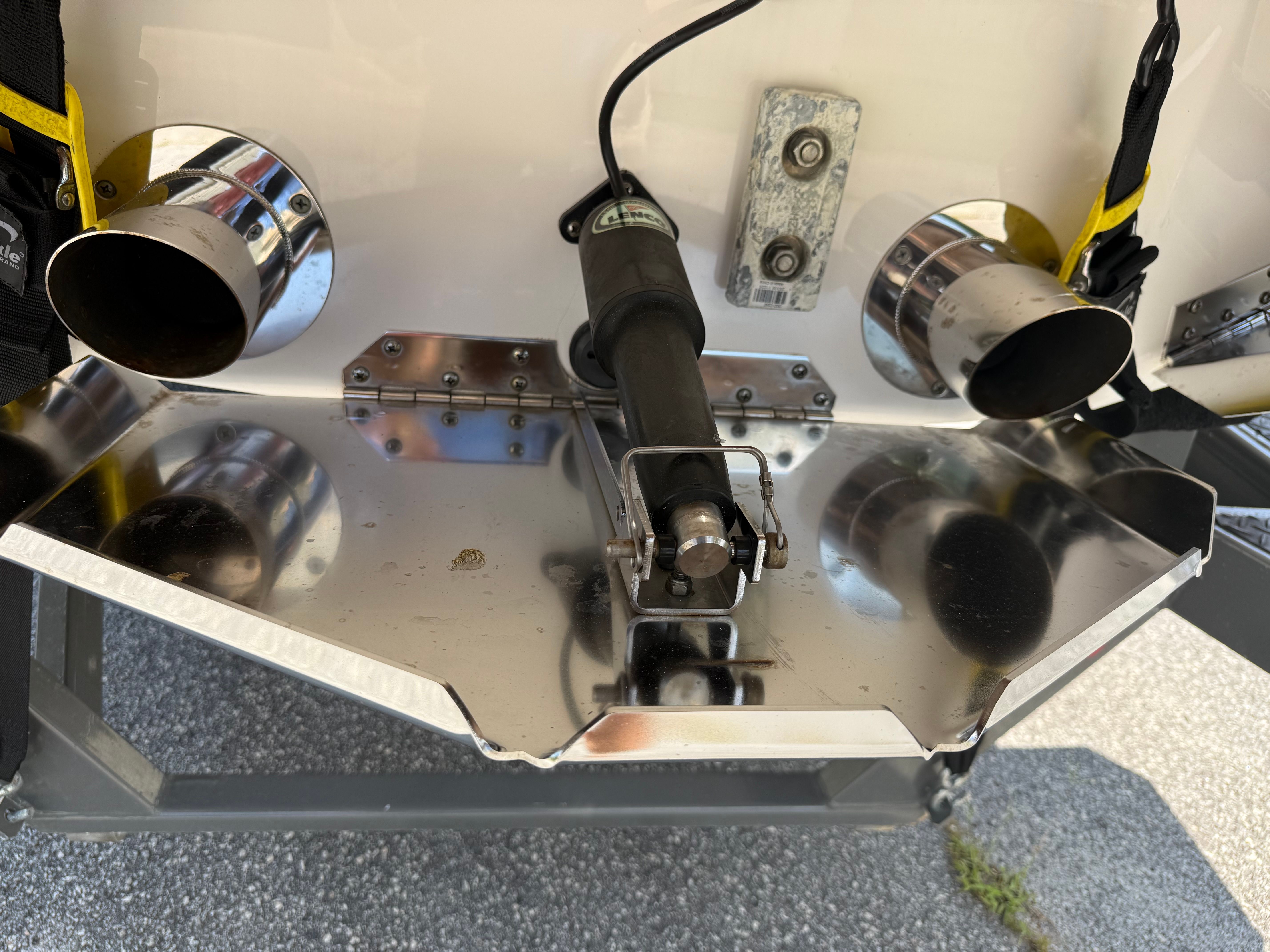 Close-up of a MasterCraft X24 boat's stern with exhaust pipes and a hydraulic system.