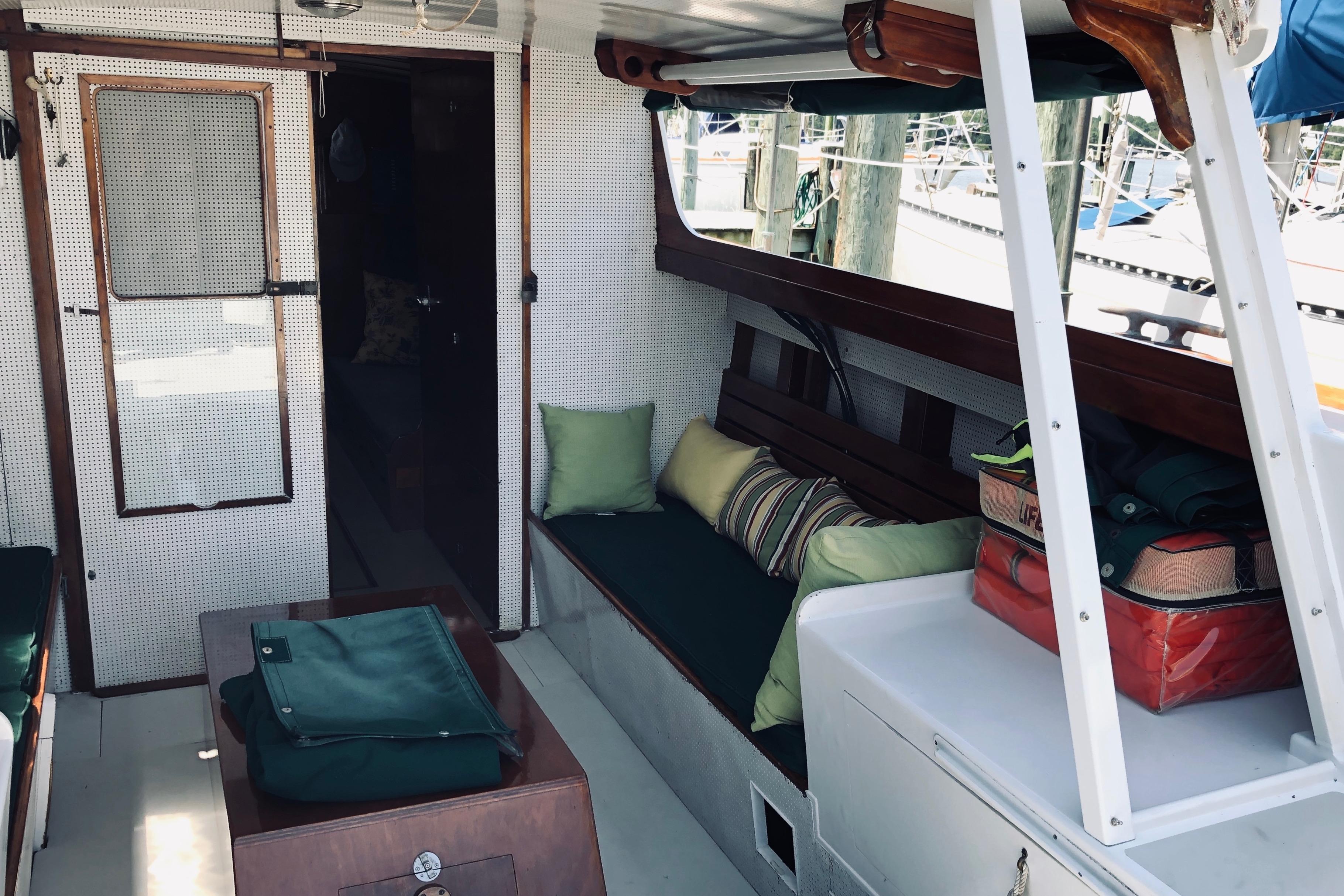 Interior of a 1963 Wiley Trawler with seating, cushions, and nautical decor.