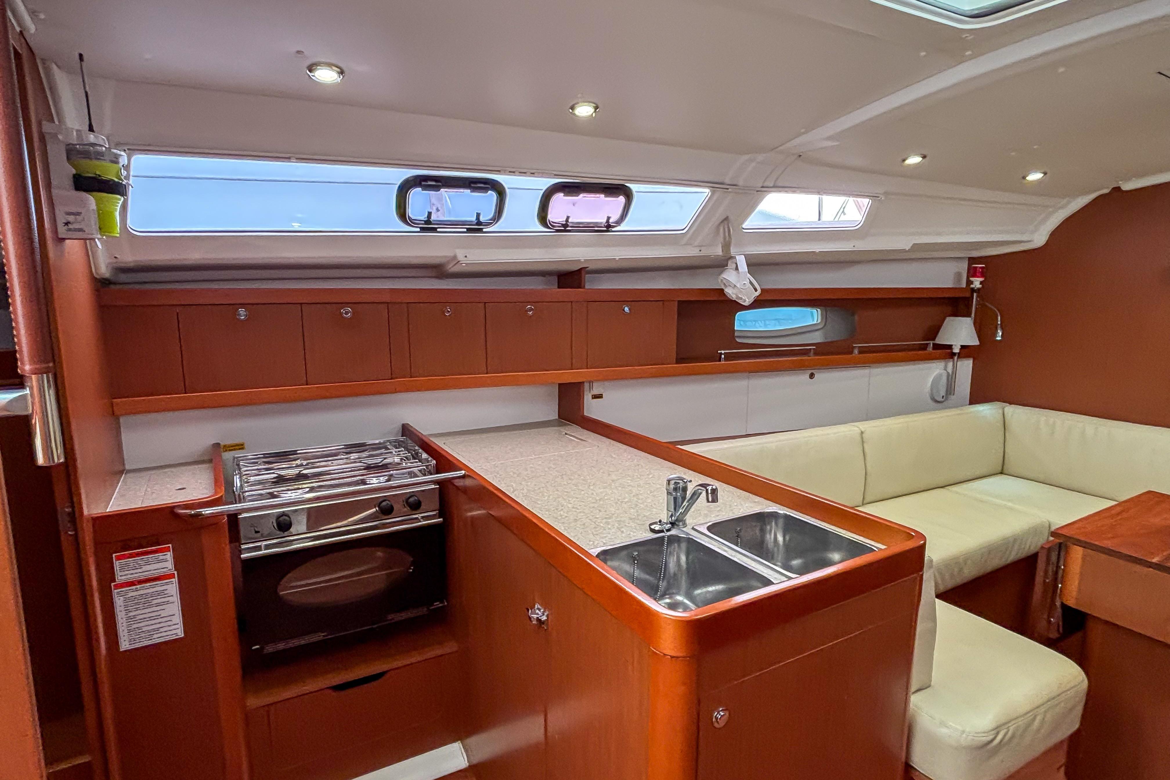 Interior of 2015 Beneteau Oceanis 37 yacht with kitchen and seating area.