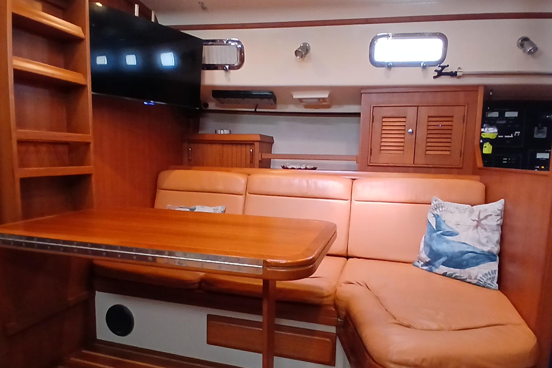 Interior of 2006 Island Packet 440 yacht with leather seating and wooden table.