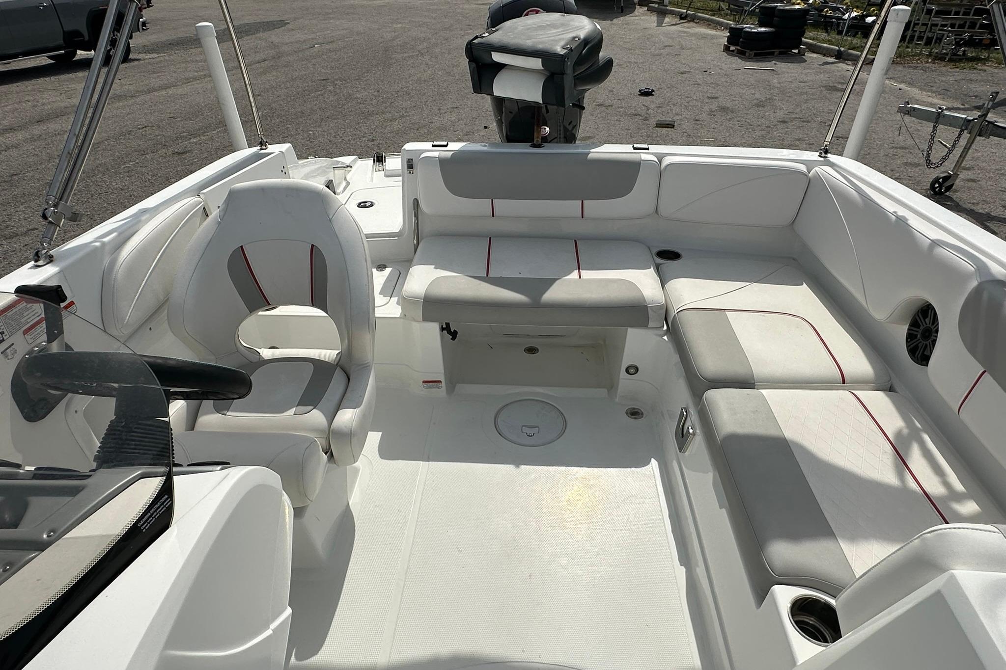 Interior of a 2021 Tahoe 2150 boat with white seating and steering console.