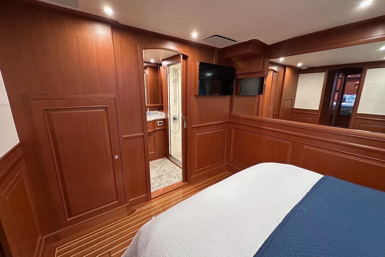 Luxurious cabin interior of 2024 Northwest 55 yacht with wood paneling and ensuite bathroom.