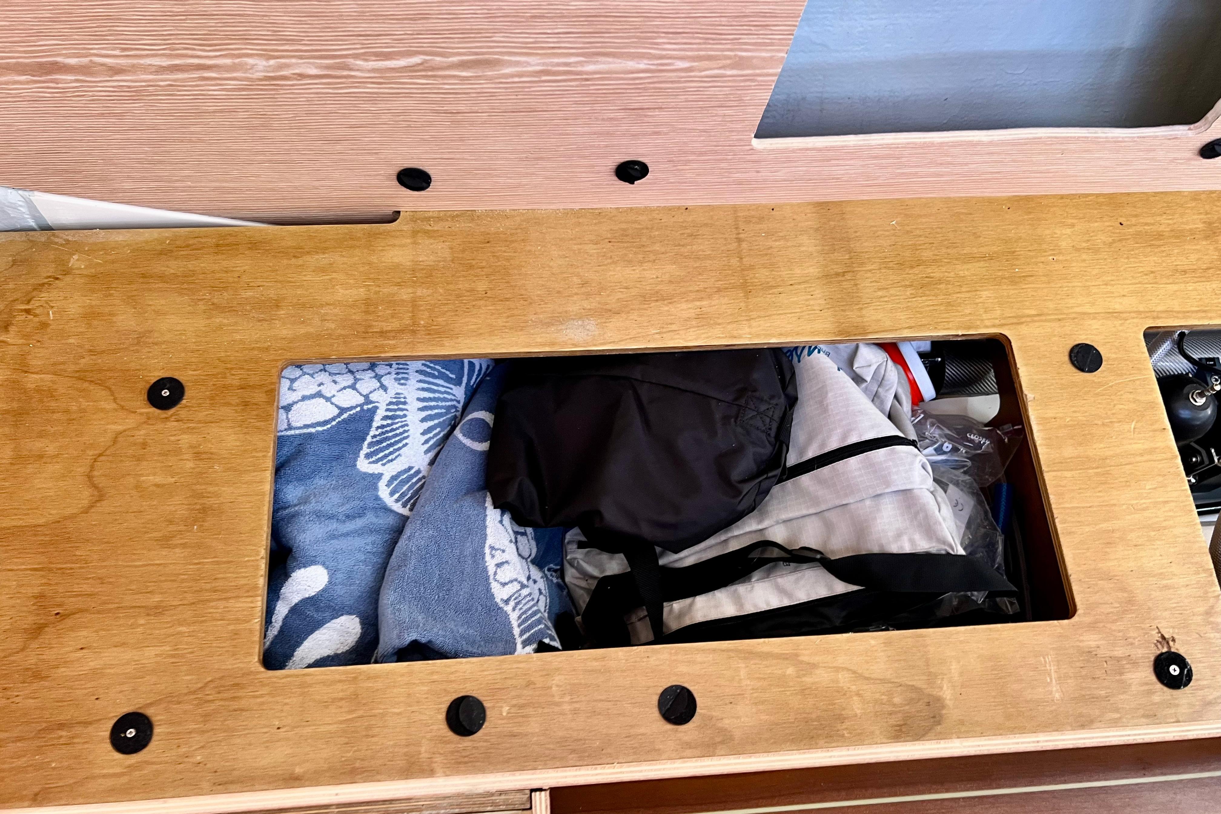 Storage compartment on a 2016 Hanse 455 yacht, containing towels and gear.