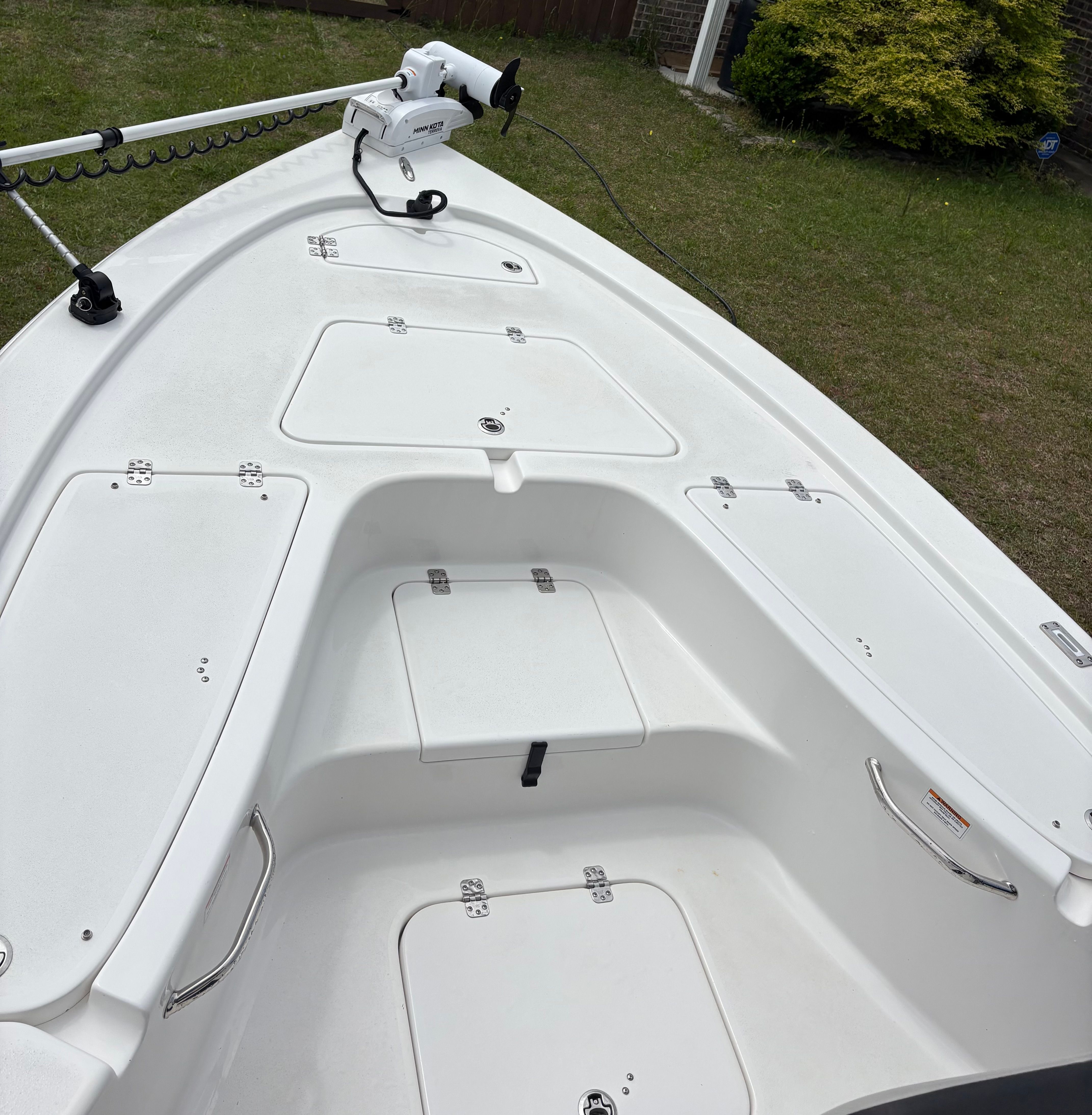2025 Sea Pro 230 Bay boat with storage compartments and controls.
