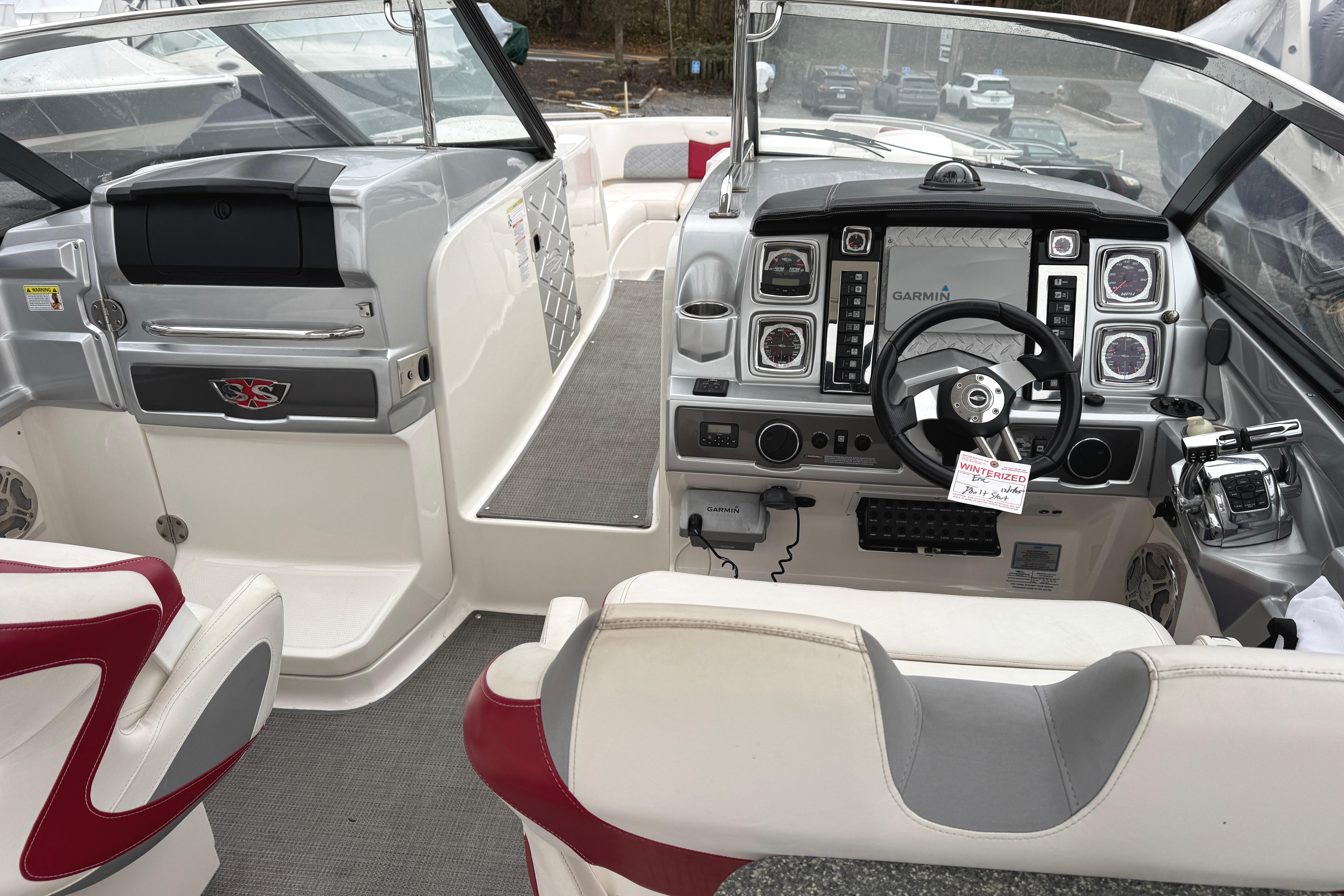 Interior view of 2012 Chaparral 327 SSX boat cockpit with steering wheel and controls.