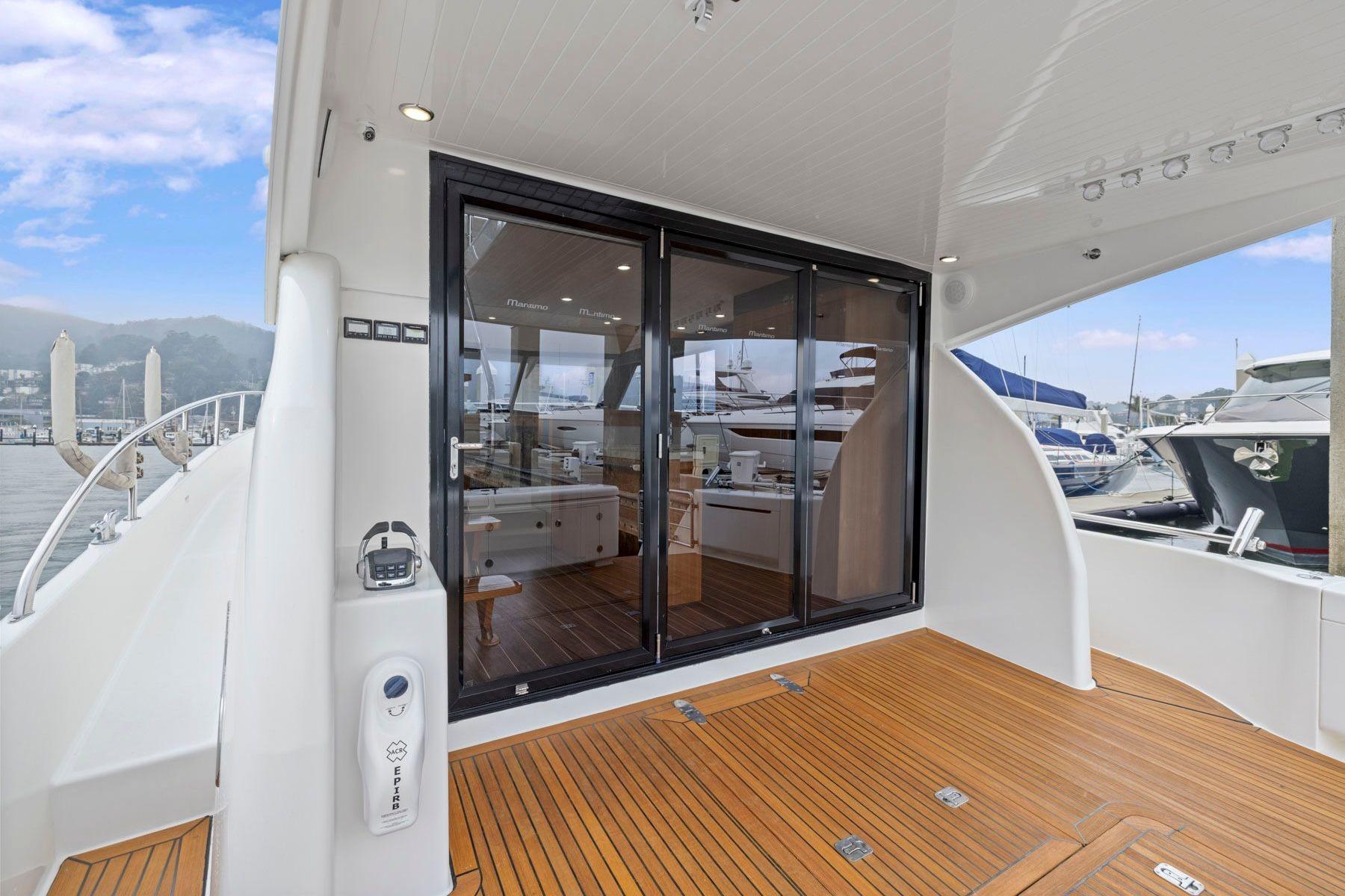2014 Maritimo M50 yacht deck with sliding glass doors and marina view.