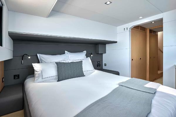 Luxurious bedroom interior of 2025 Privilege Signature 580 yacht, featuring modern design and cozy bedding.