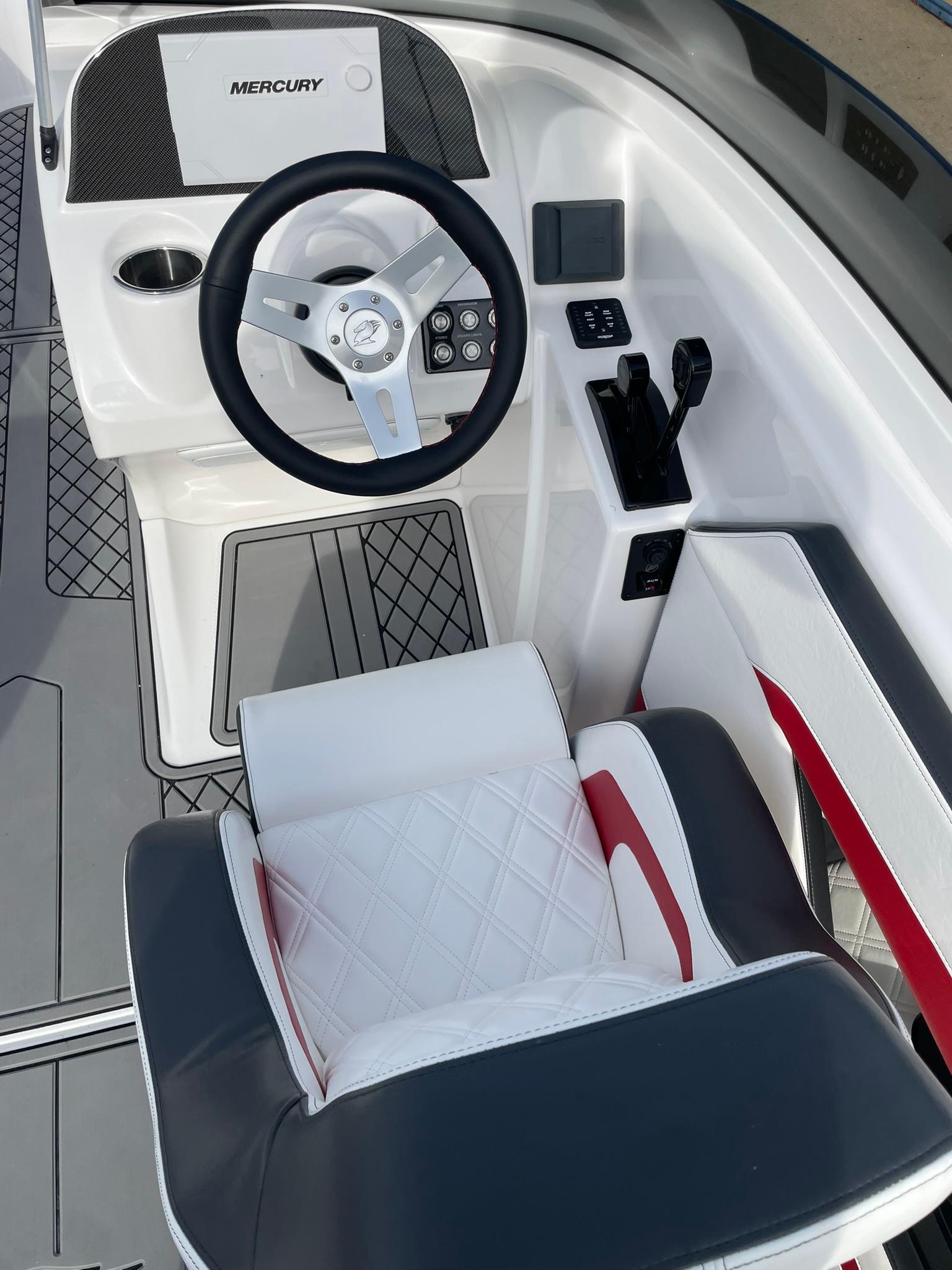 2025 Checkmate Pulsare 2400 BRX boat cockpit with steering wheel and seating.