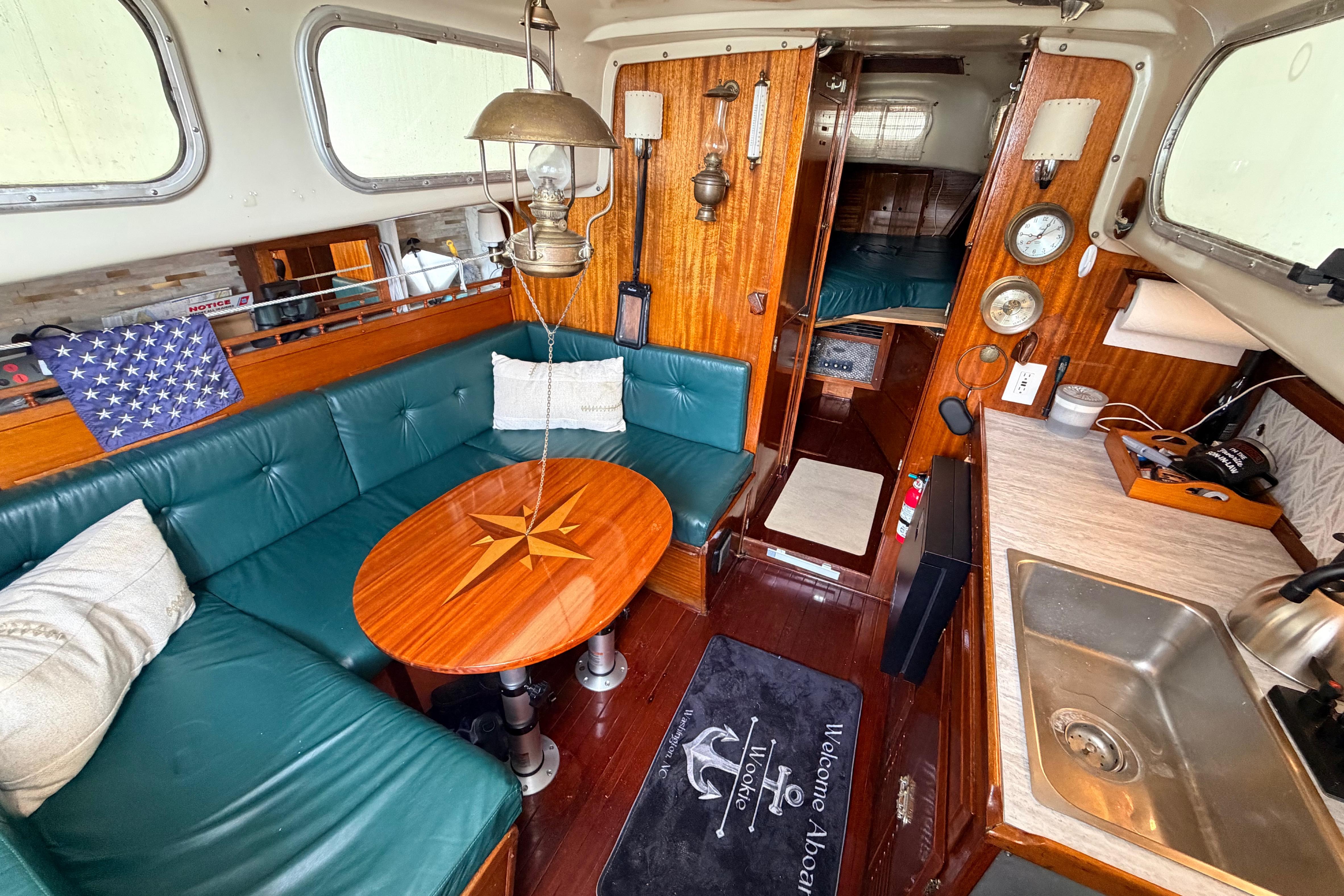 Interior of a 1964 Columbia 33 sailboat with cozy seating and nautical decor.