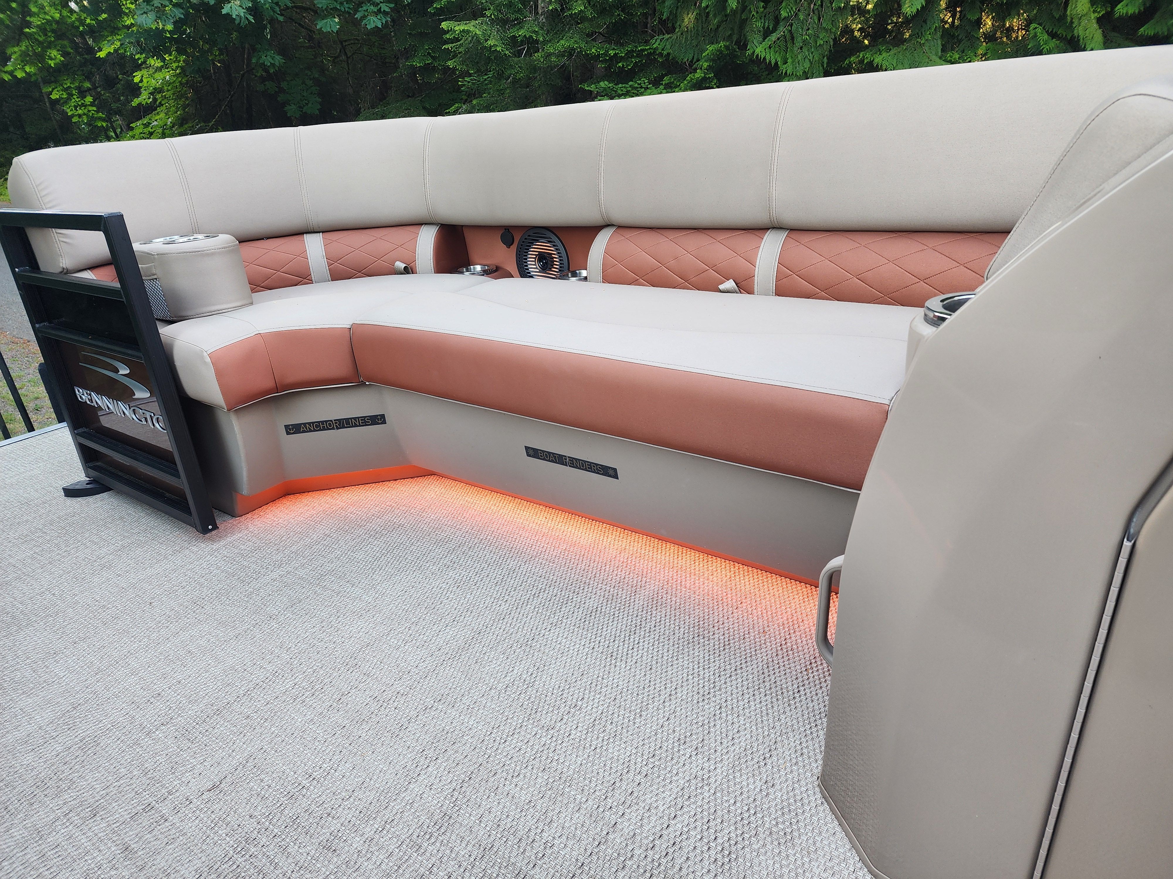 The image shows the interior of a Bennington 22 LSB boat with cushioned seating and LED lighting.